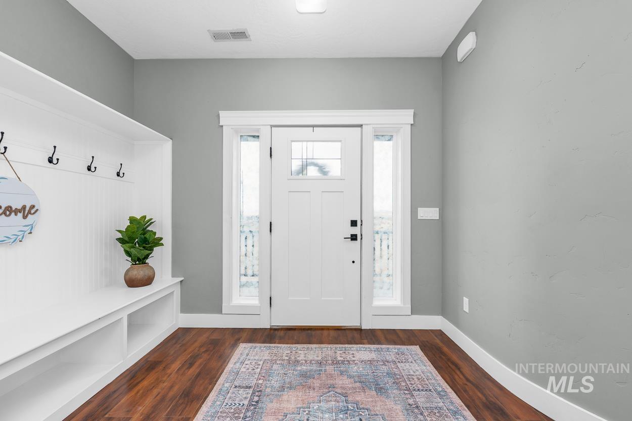Entrance foyer featuring dark wood-type flooring and baseboards
