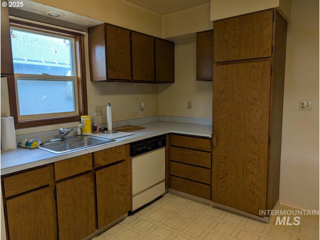 Kitchen with light countertops, white dishwasher, and light floors
