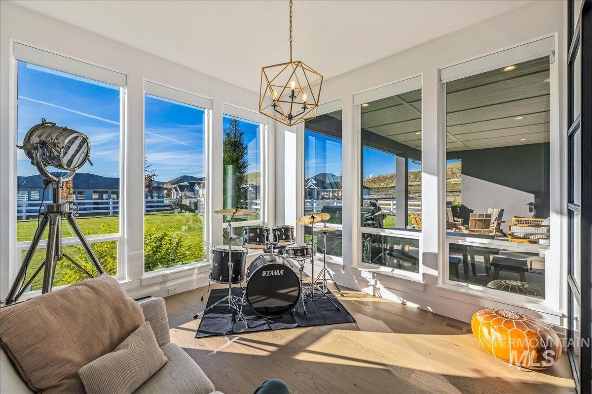 Sunroom / solarium with hardwood / wood-style floors and a chandelier