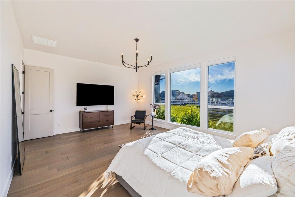Bedroom with wood finished floors and a chandelier