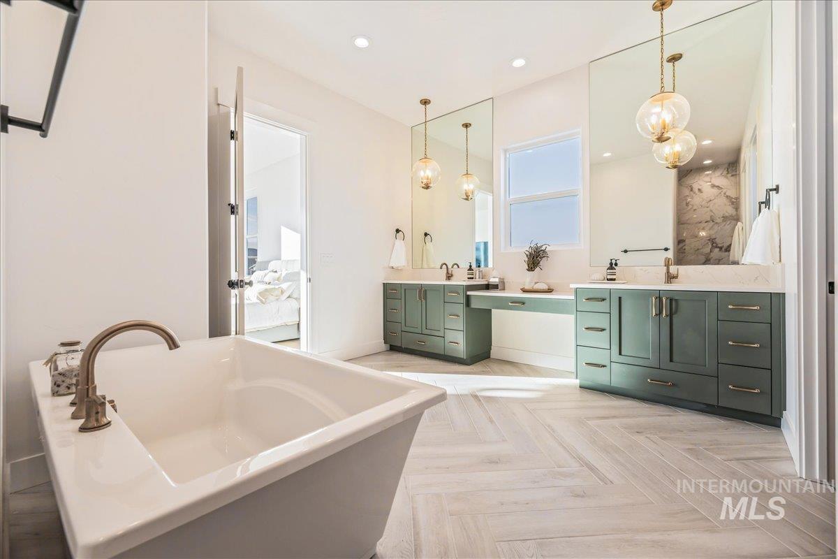 Bathroom featuring vanity, a freestanding bath, and recessed lighting