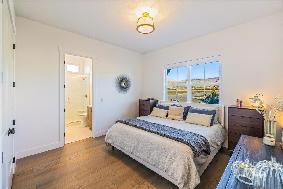 Bedroom featuring hardwood / wood-style floors and connected bathroom