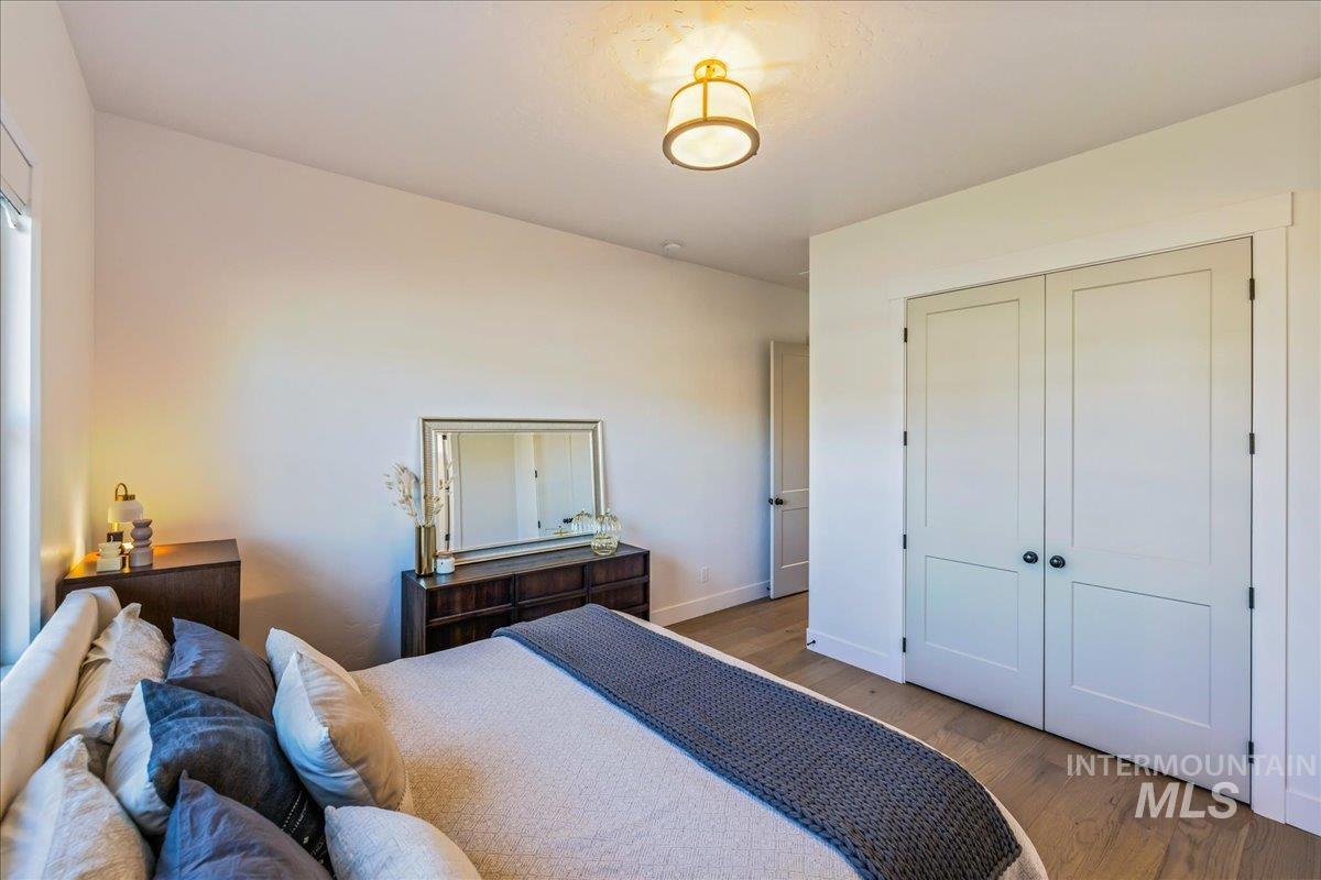 Bedroom with wood finished floors and a closet