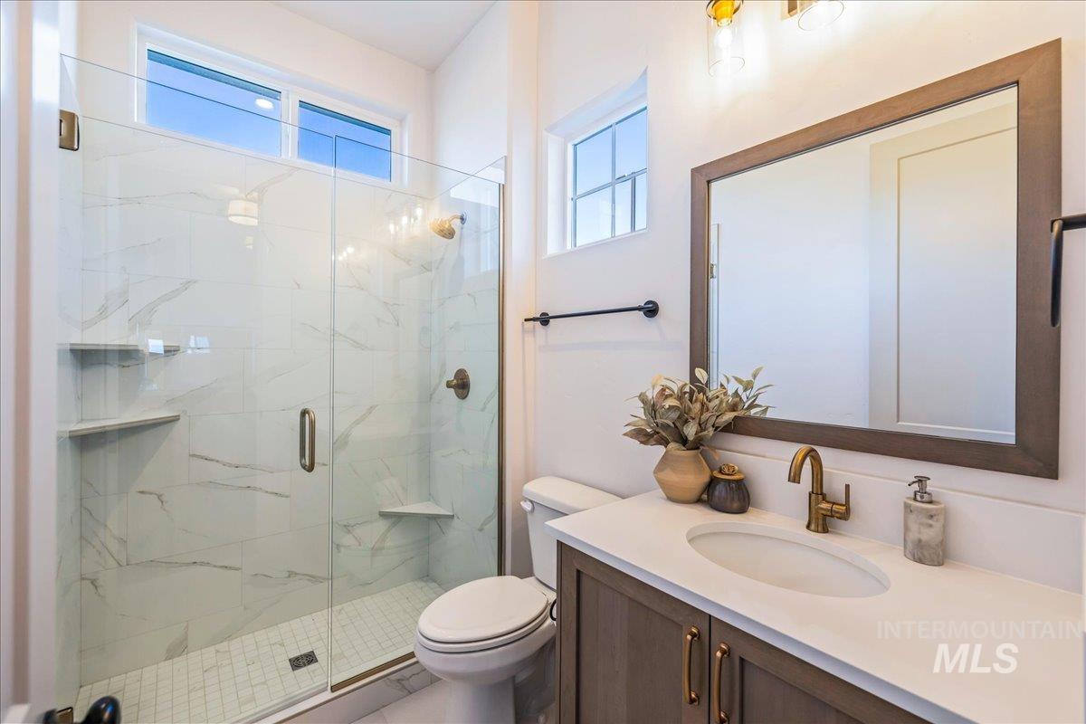Bathroom with vanity and a marble finish shower