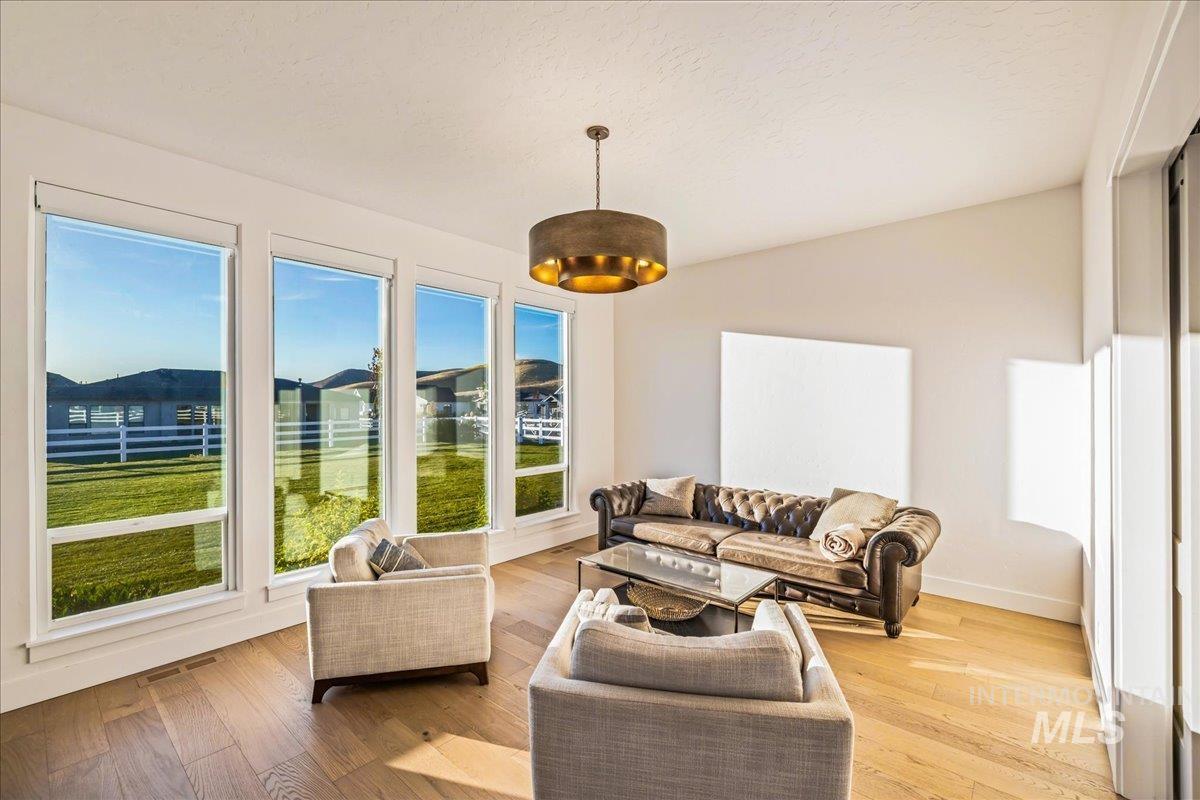 Living room with plenty of natural light, light wood-style floors, and a textured ceiling