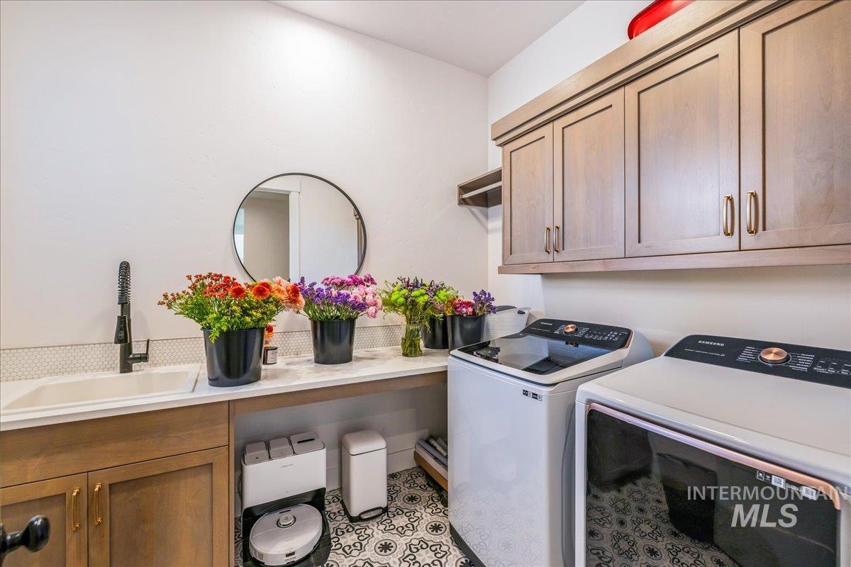 Laundry room featuring cabinet space, washing machine and dryer, and light tile patterned flooring