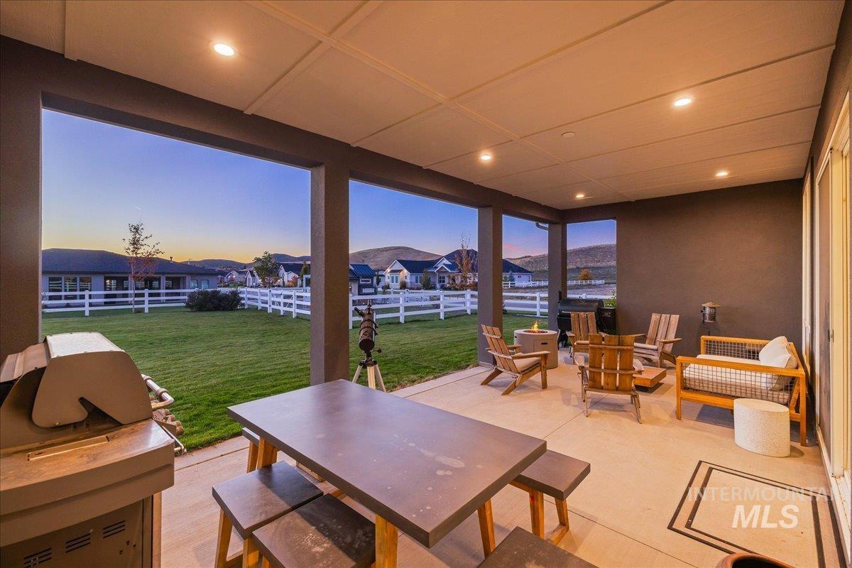 Fenced backyard with a patio area, area for grilling, outdoor dining area, a mountain view, and an outdoor living space