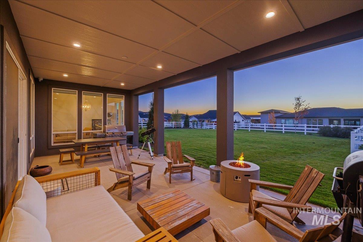 Fenced backyard with a grill, a patio area, and an outdoor living space with a fire pit