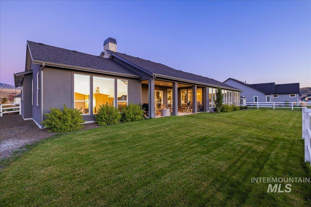 Rear view of property with a chimney, a patio area, and stucco siding
