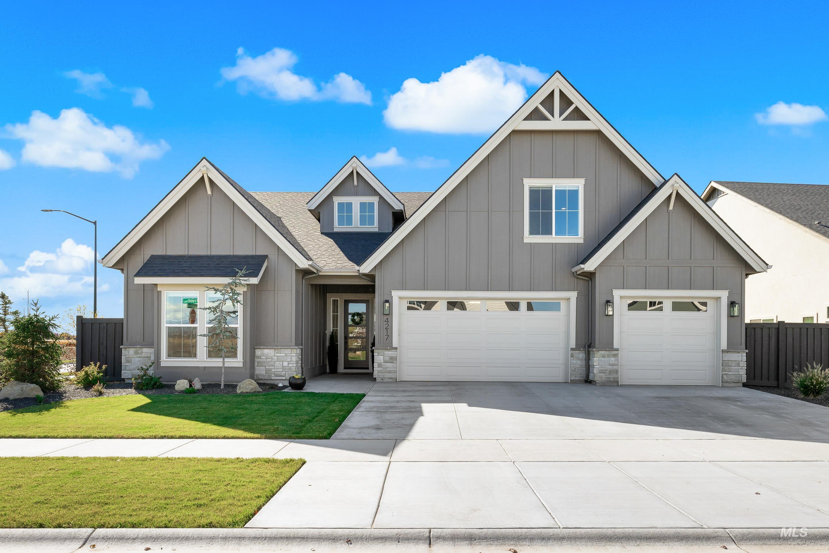 Craftsman-style house with board and batten siding, a shingled roof, and stone siding