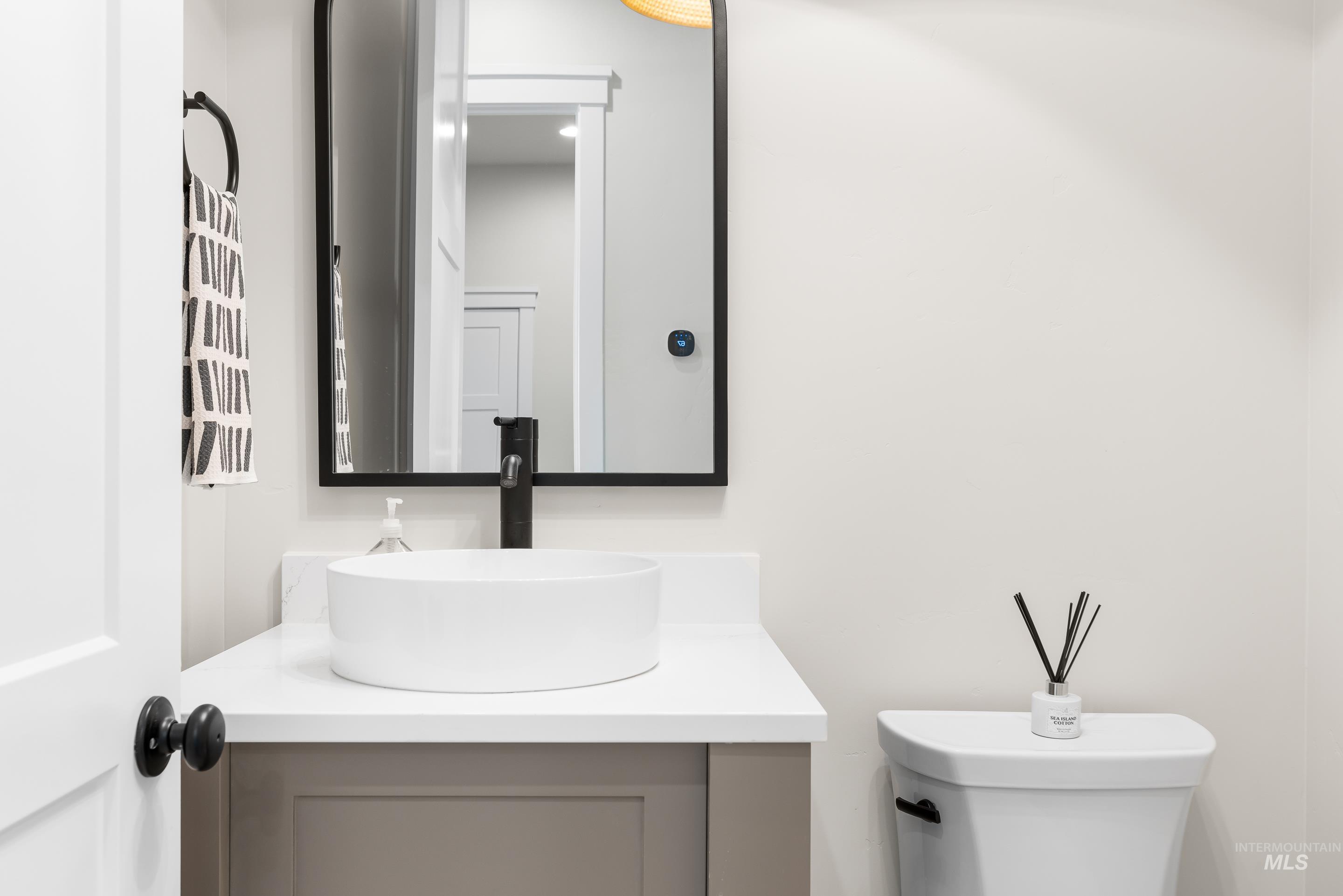 Half bathroom featuring vanity and toilet
