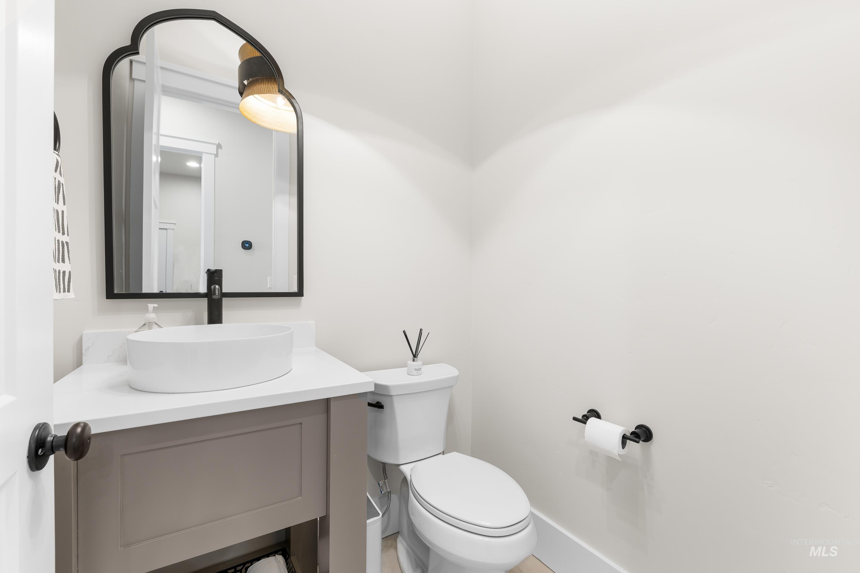 Half bathroom featuring vanity and toilet