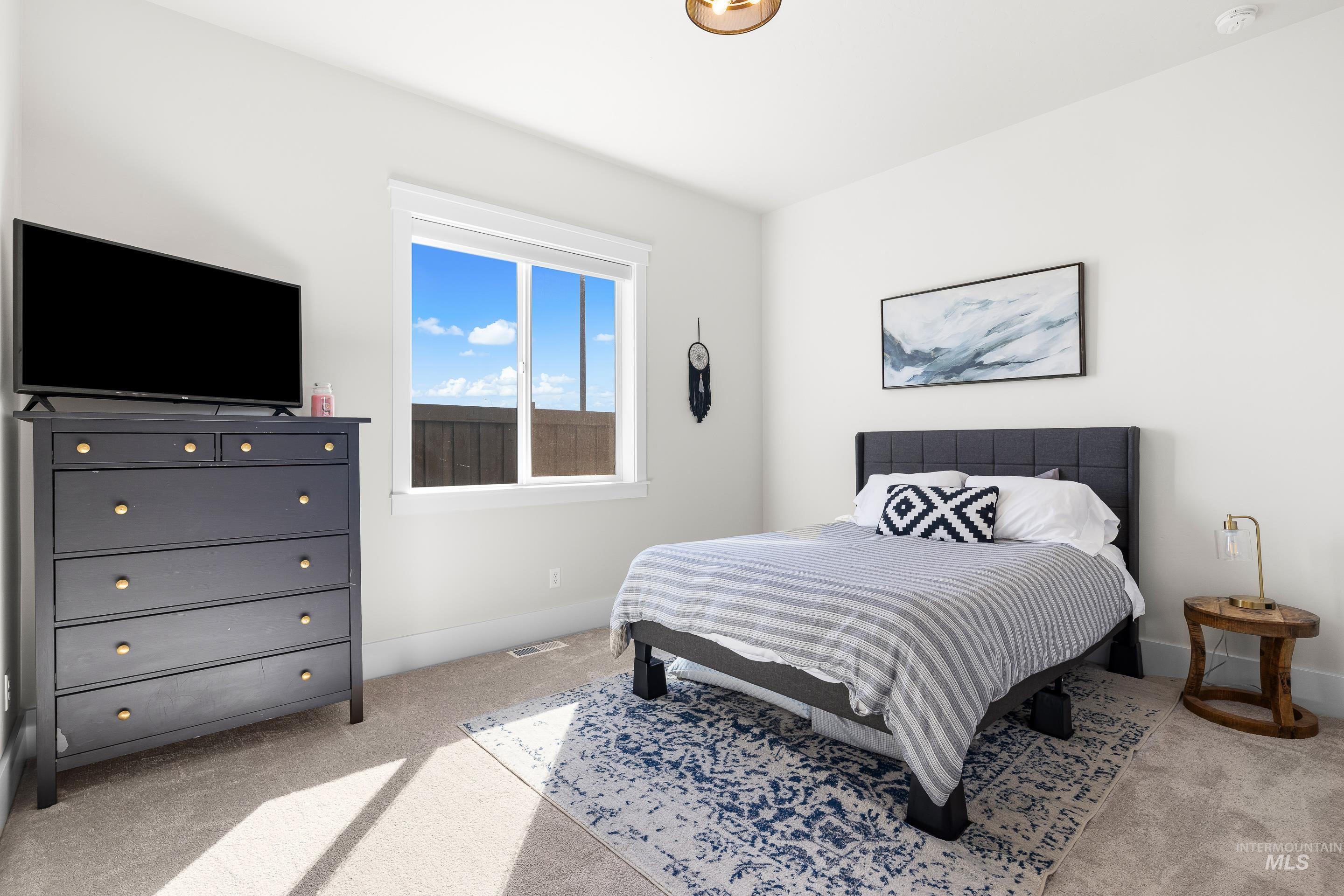 Bedroom featuring light colored carpet and baseboards