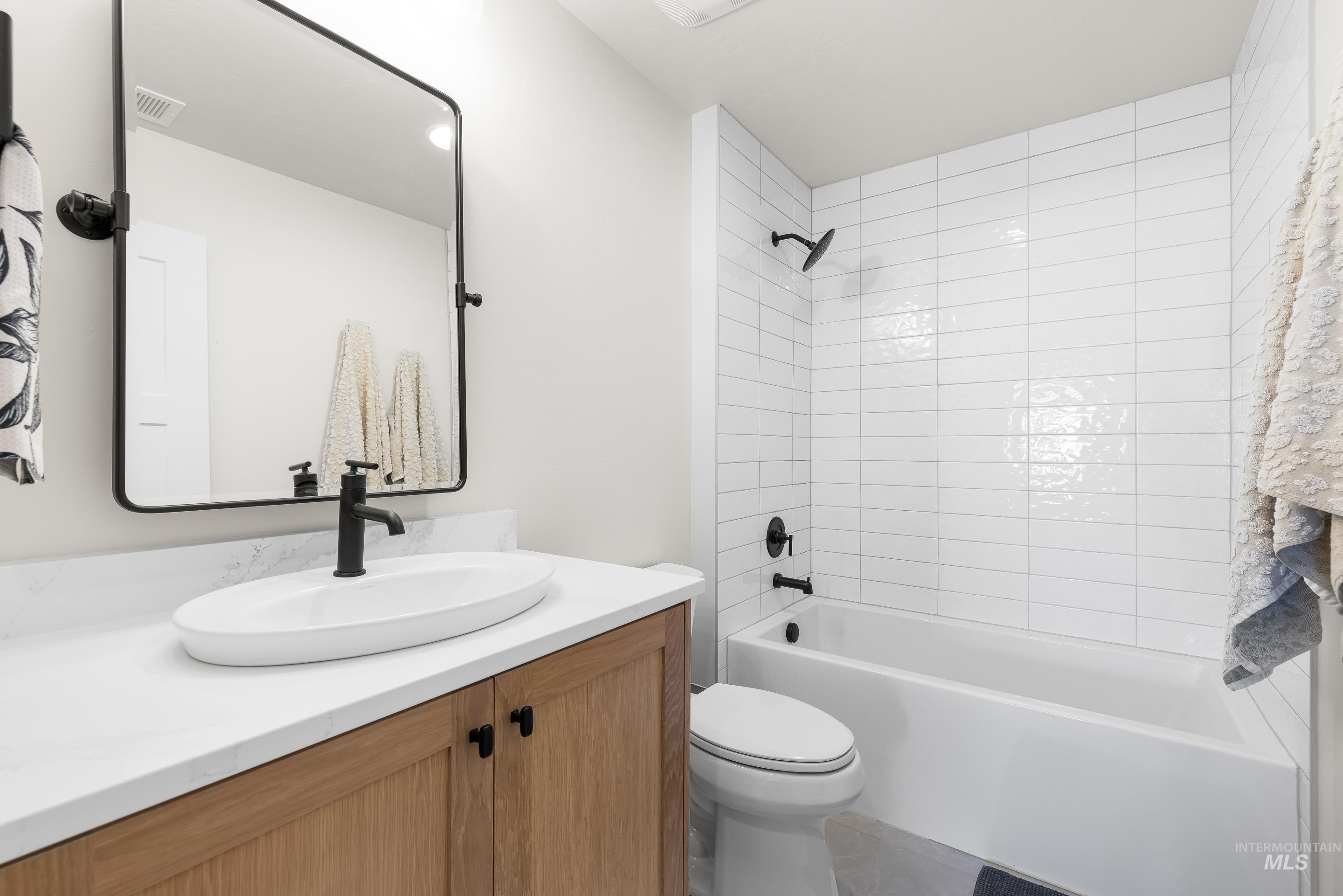 Full bath with vanity and shower / bath combination