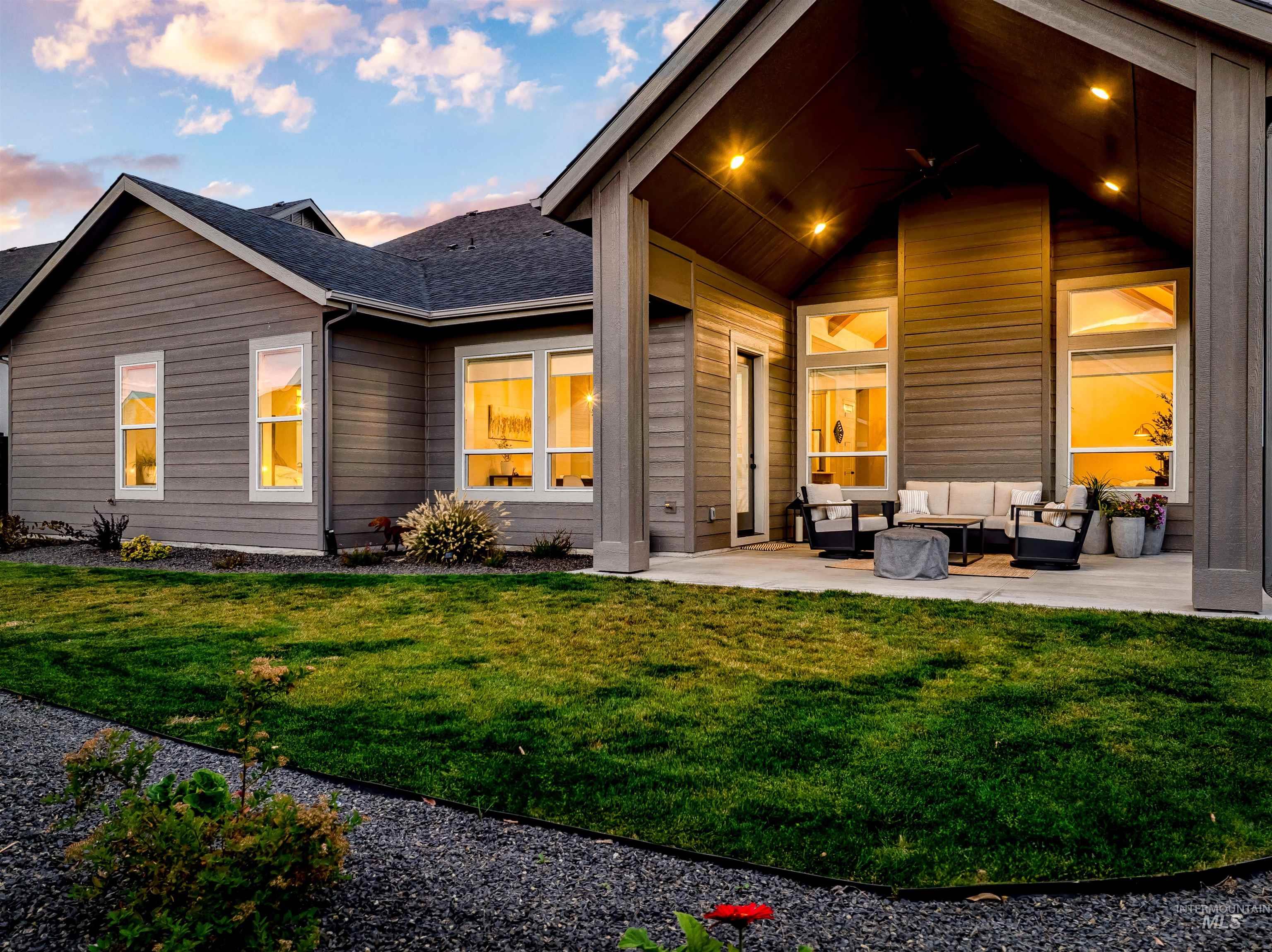 Back of house at dusk with outdoor lounge area, a patio area, and a yard