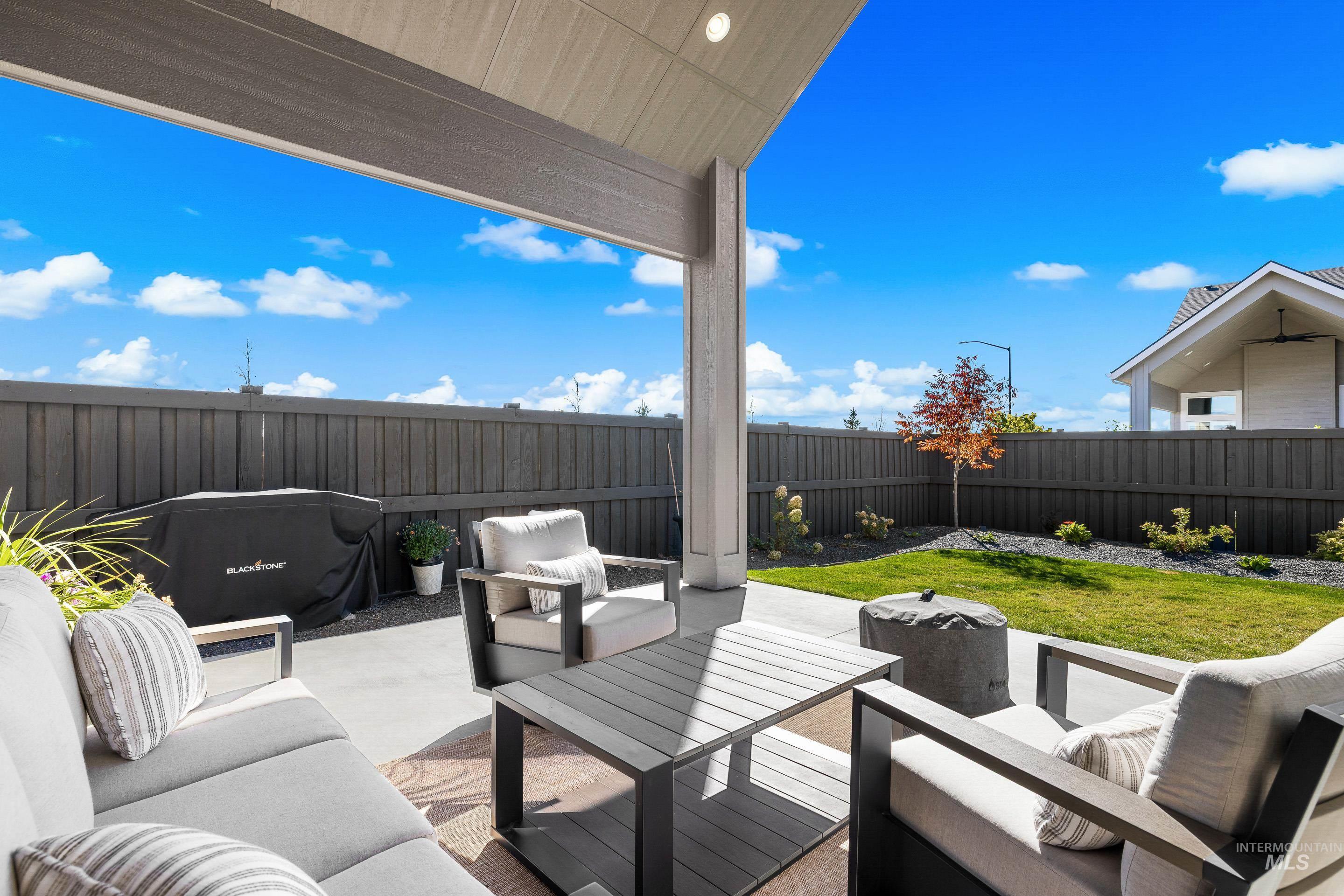 Fenced backyard featuring an outdoor hangout area and a patio