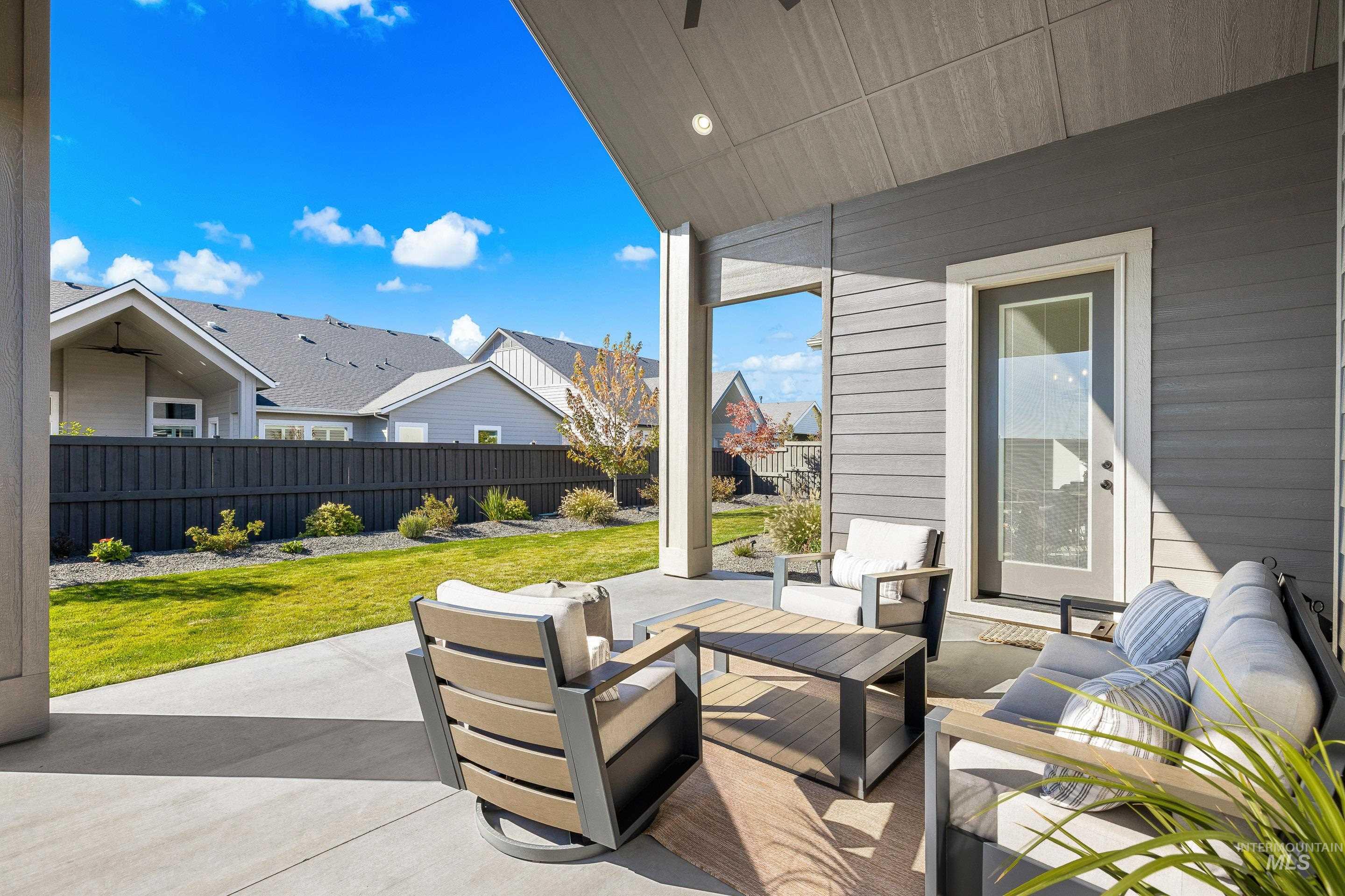 Fenced backyard with a patio, an outdoor hangout area, and a residential view