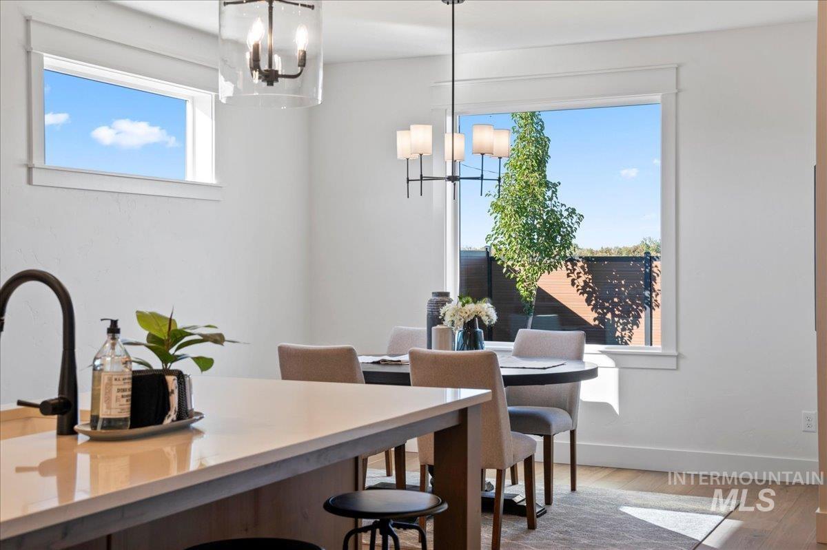 Dining area with wood finished floors and a chandelier