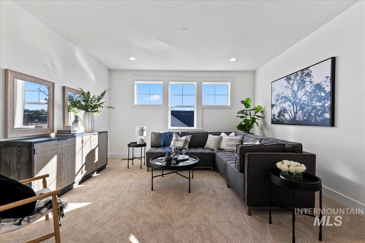 Carpeted living area with recessed lighting and baseboards