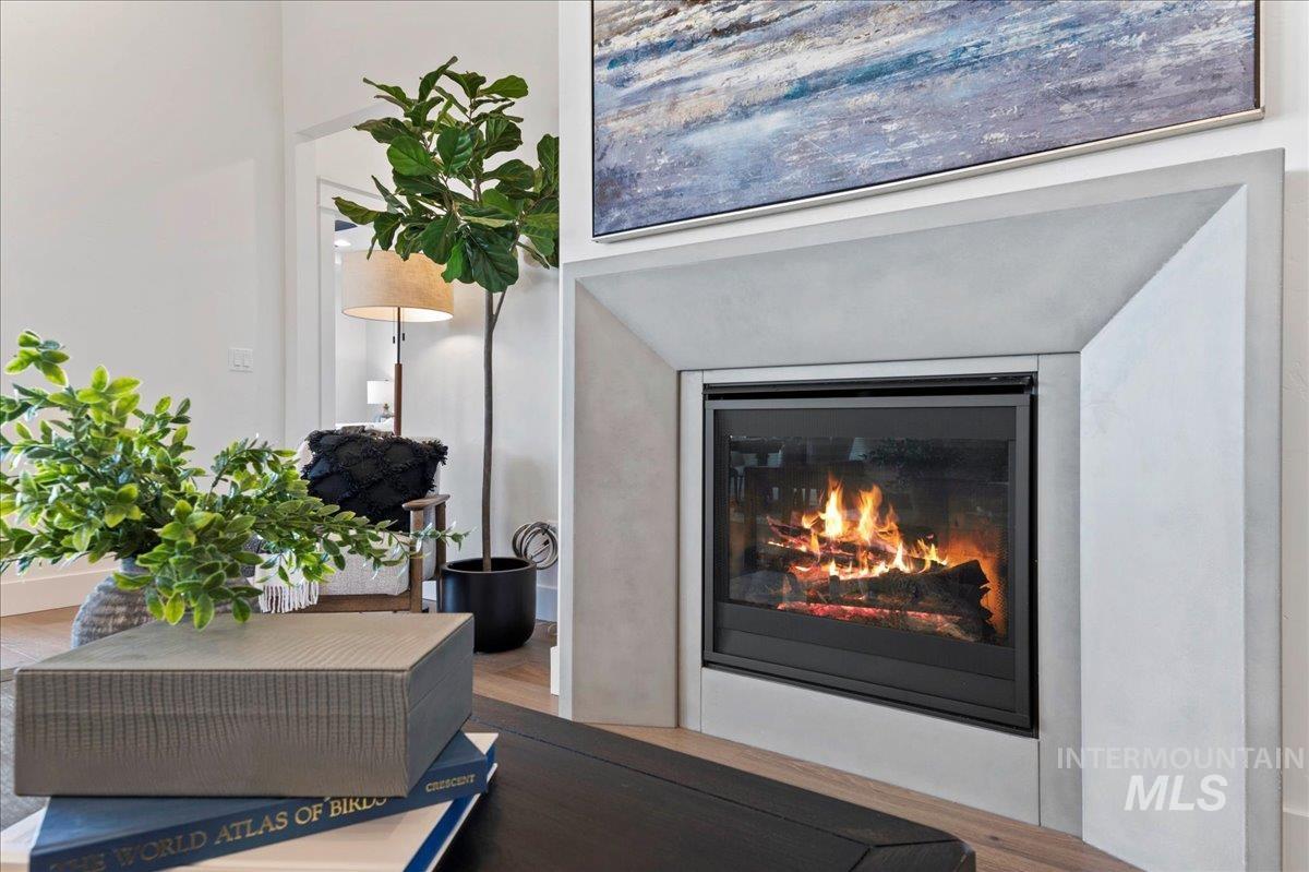 Detailed view of wood finished floors and a glass covered fireplace