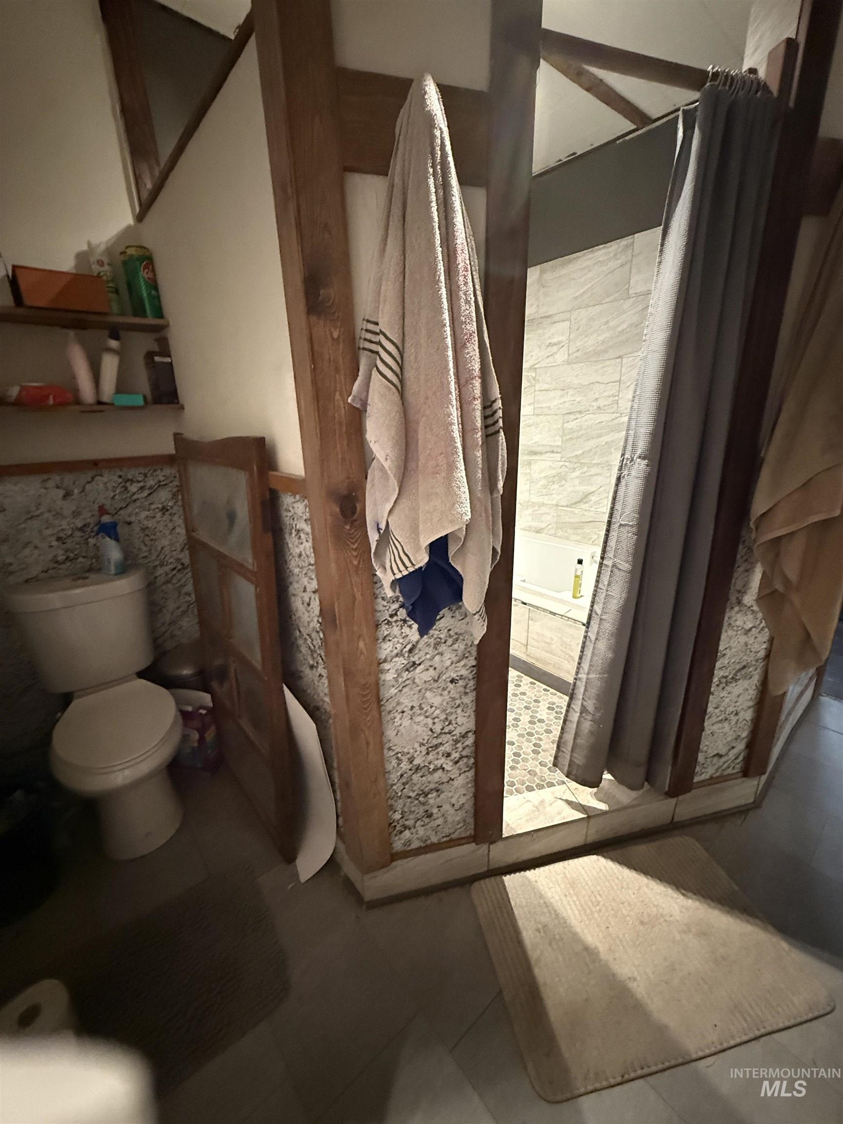 Bathroom with a wainscoted wall and tile patterned flooring