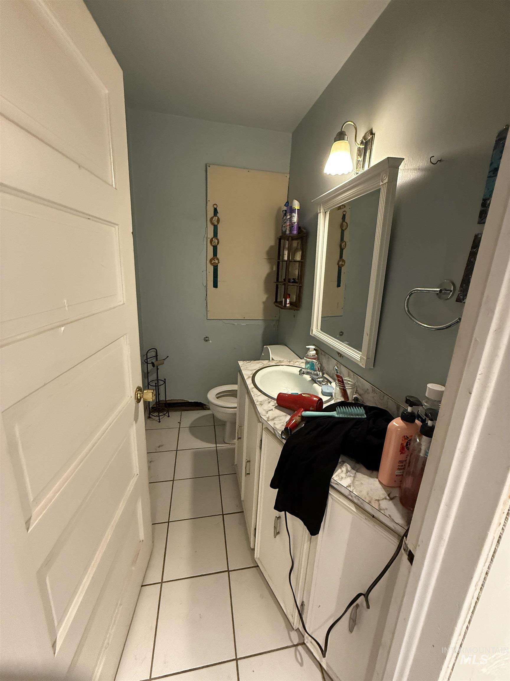 Bathroom with light tile patterned floors and vanity