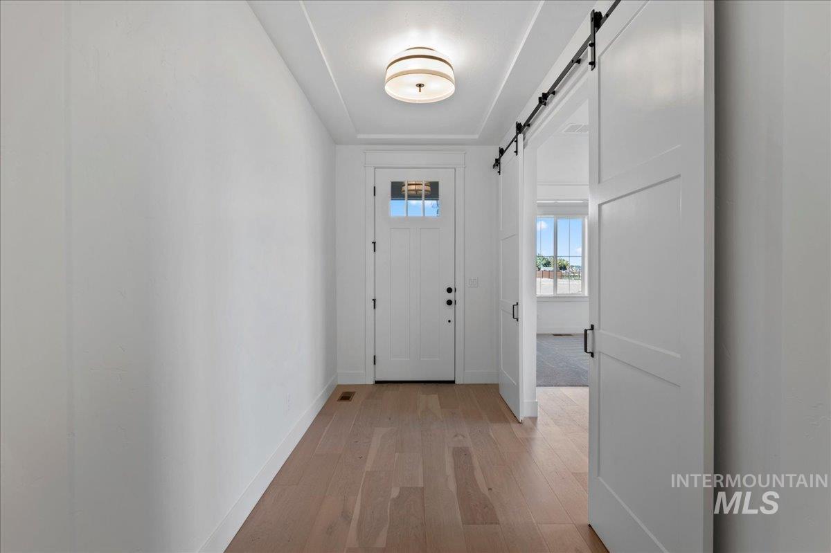 Foyer entrance featuring light wood finished floors and a barn door