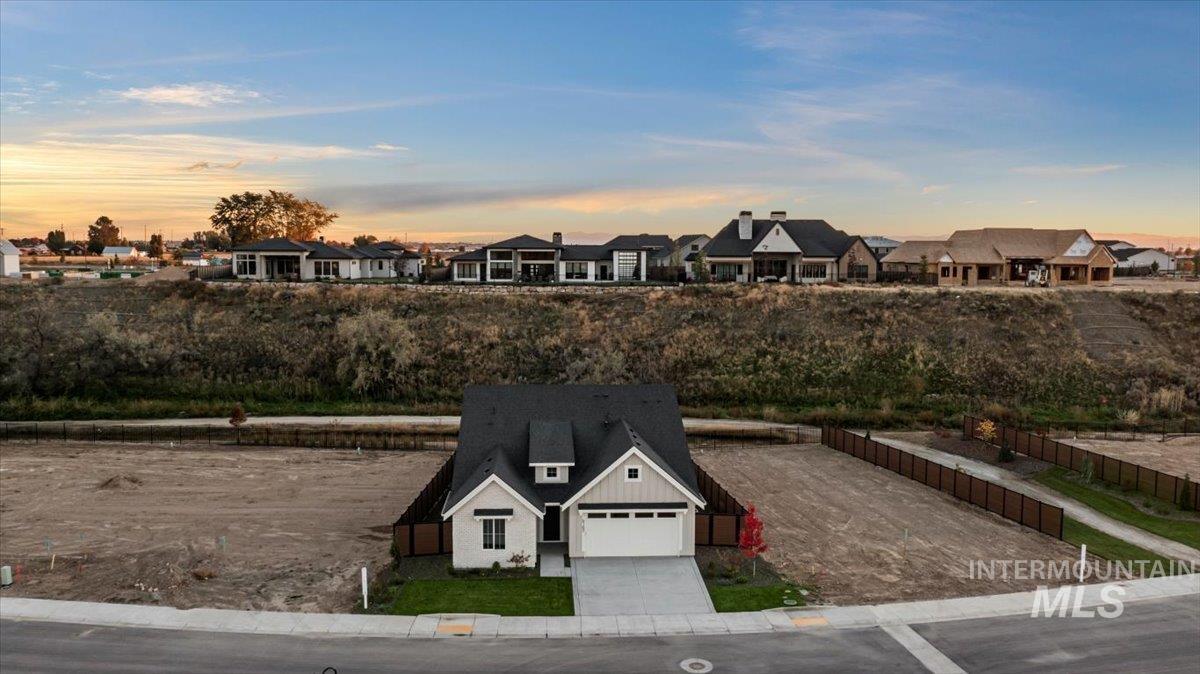 Yard at dusk featuring concrete driveway, a garage, and a residential view