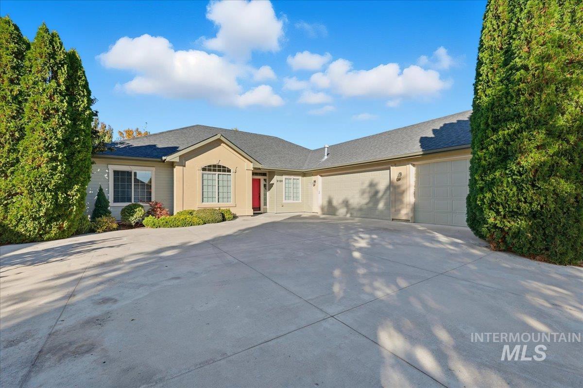 Ranch-style home featuring an attached garage, concrete driveway, and a shingled roof