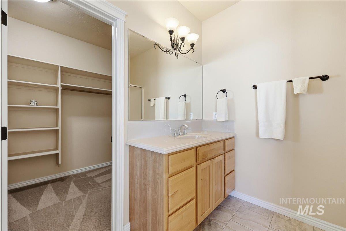 Bathroom featuring vanity, a spacious closet, and light tile patterned floors