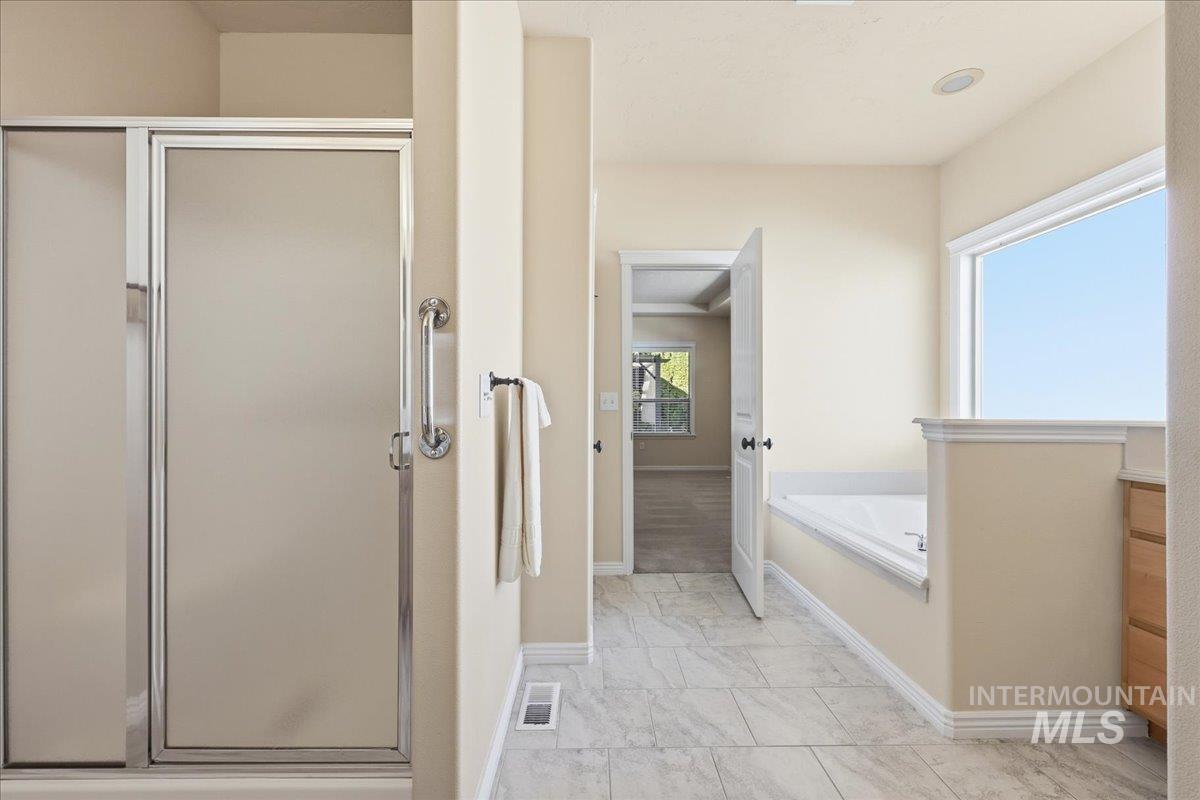Full bath with a stall shower and a bath