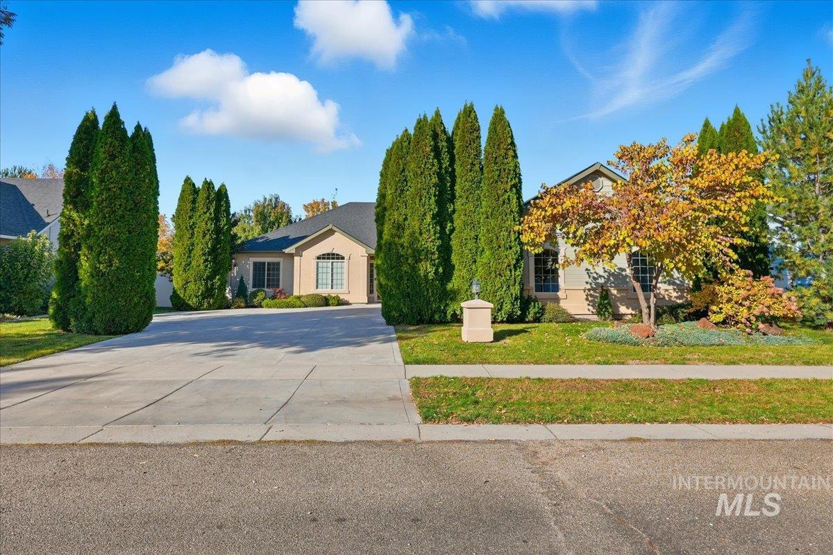 Obstructed view of property featuring driveway and a front lawn