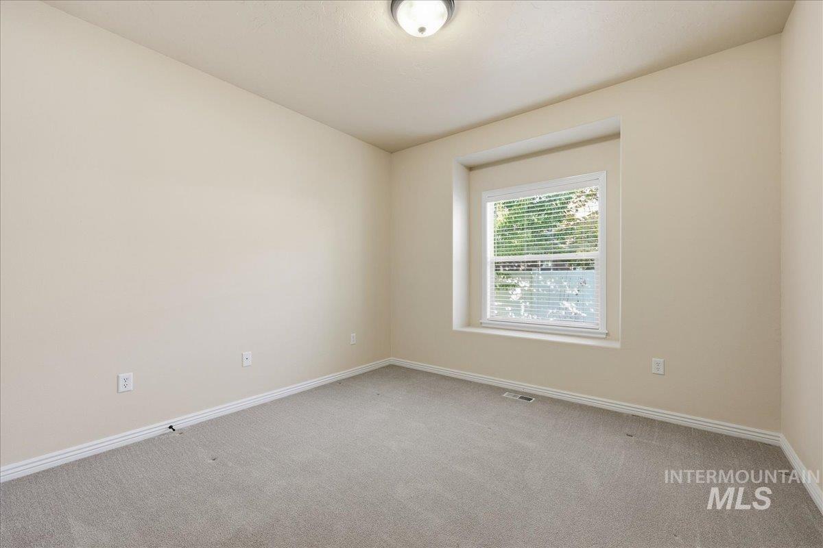 Carpeted spare room with baseboards