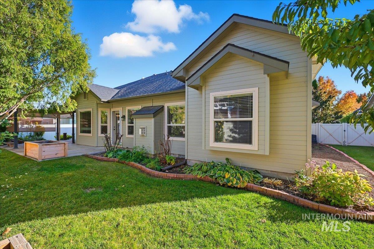 View of front of house featuring a patio, a shingled roof, and a gate