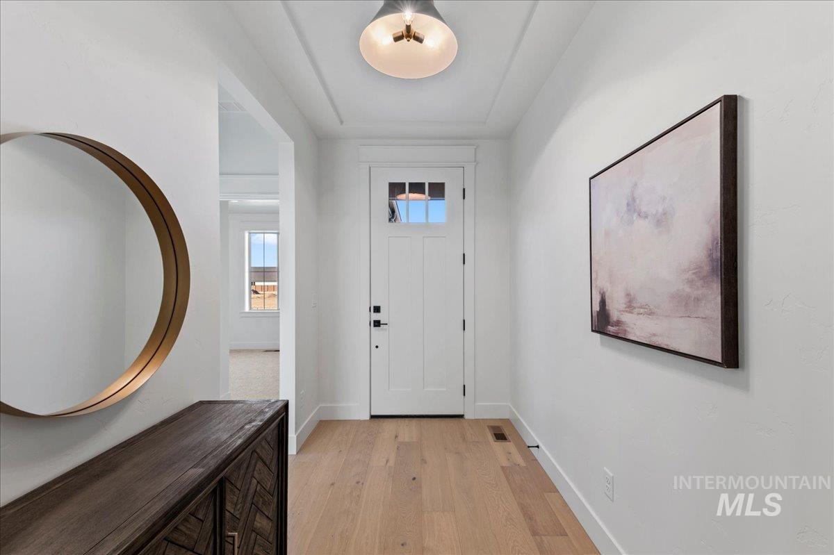 Foyer entrance with light wood-type flooring and baseboards