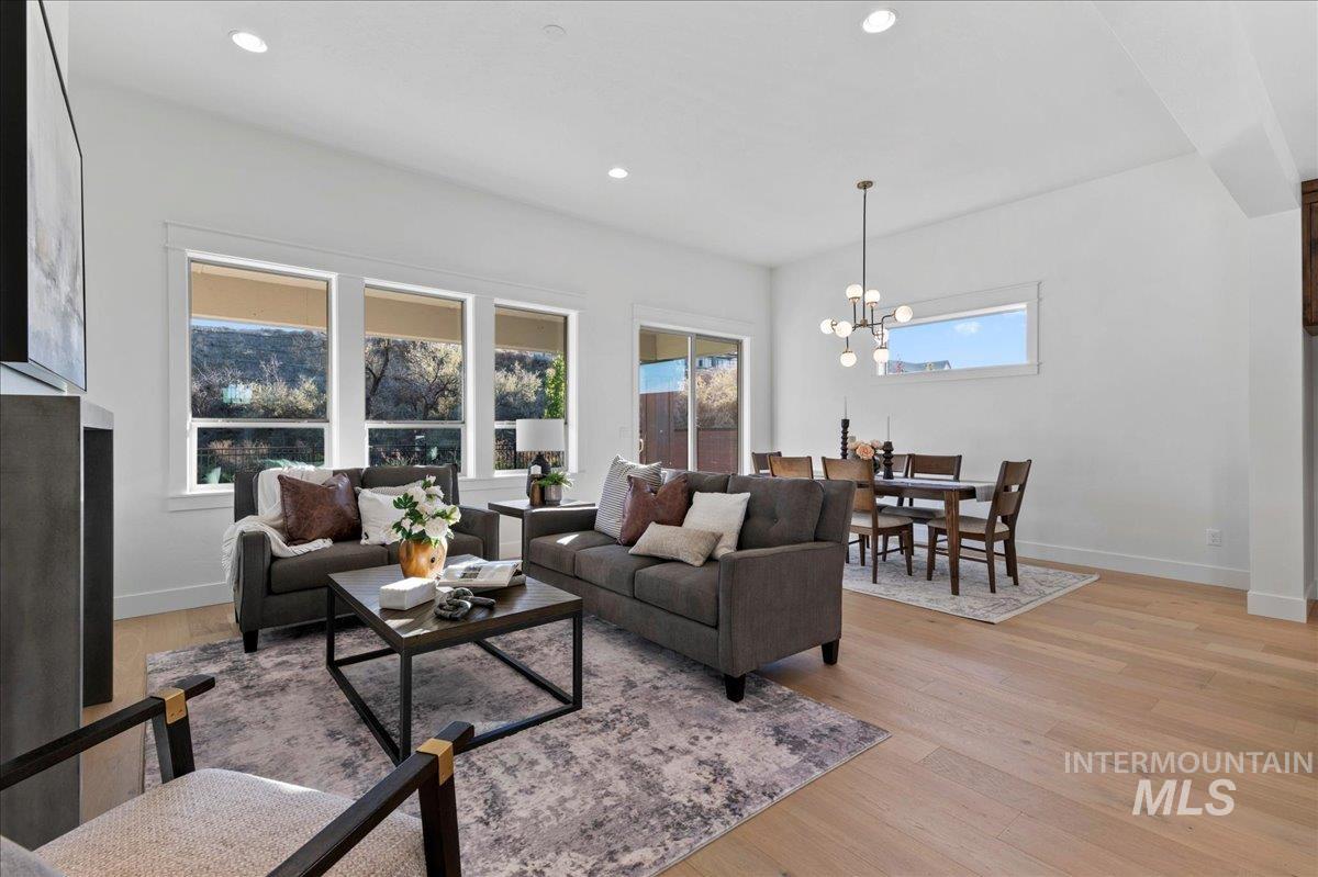 Living area with light wood finished floors, recessed lighting, and a chandelier