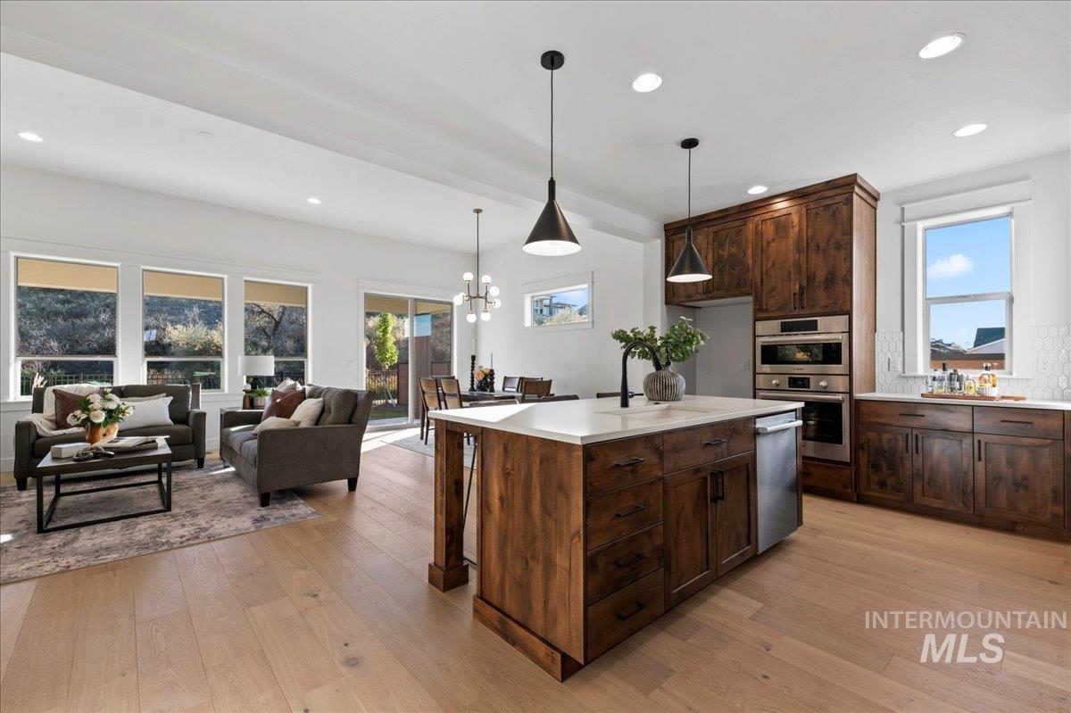 Kitchen featuring recessed lighting, a chandelier, light wood-style flooring, decorative light fixtures, and dark brown cabinetry