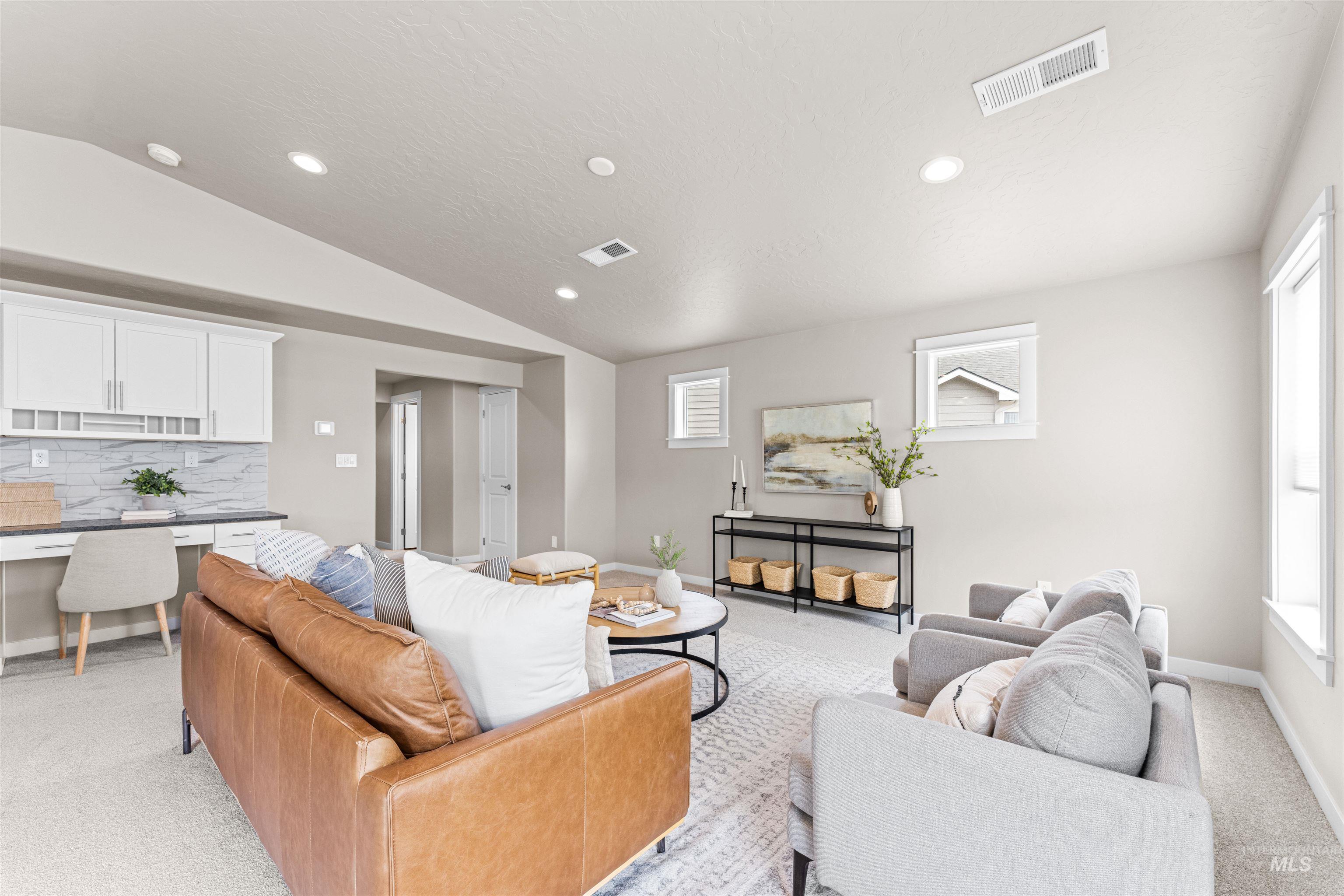 Living room featuring light carpet, recessed lighting, lofted ceiling, and built in study area