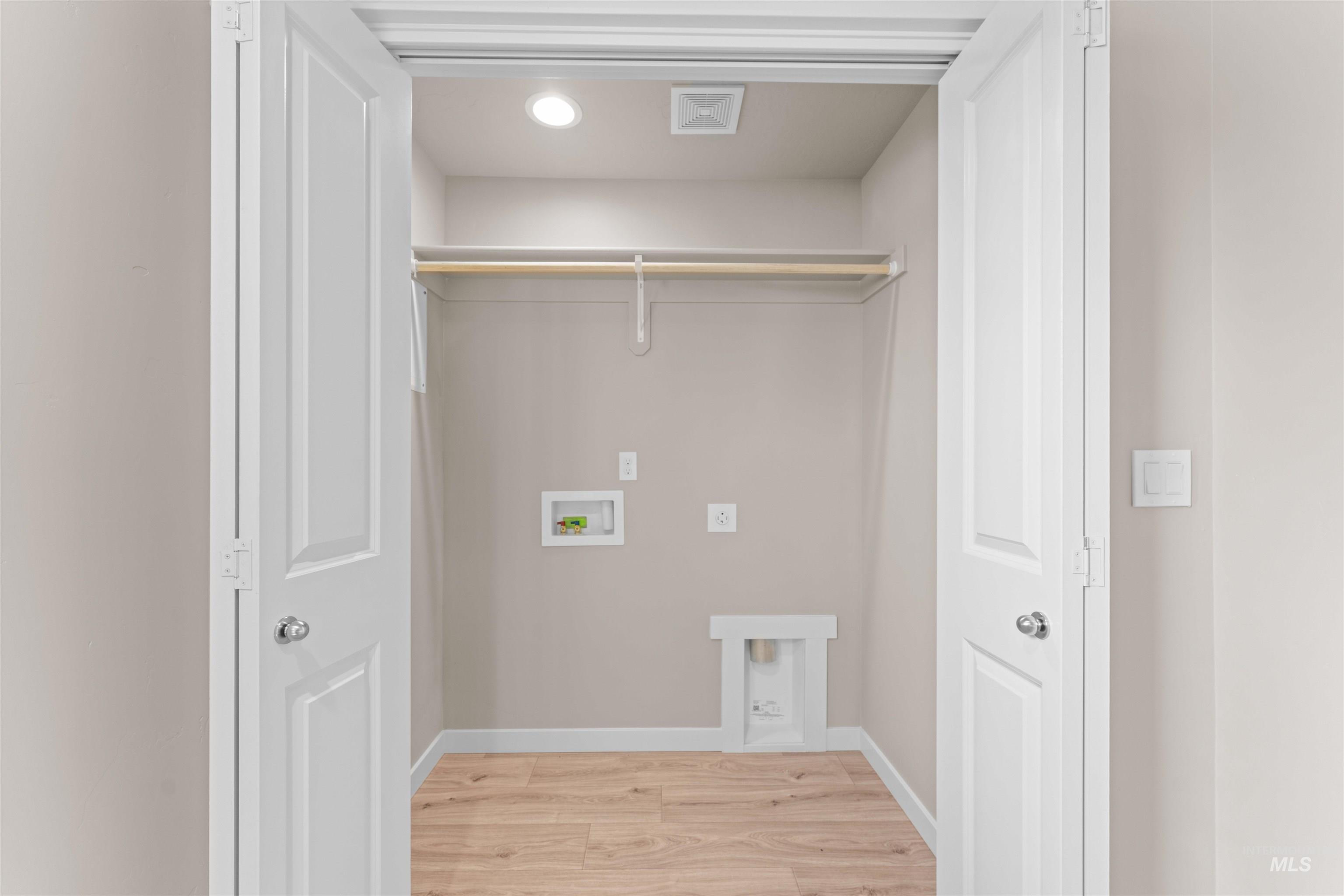 Washroom featuring light wood-type flooring, washer hookup, and recessed lighting