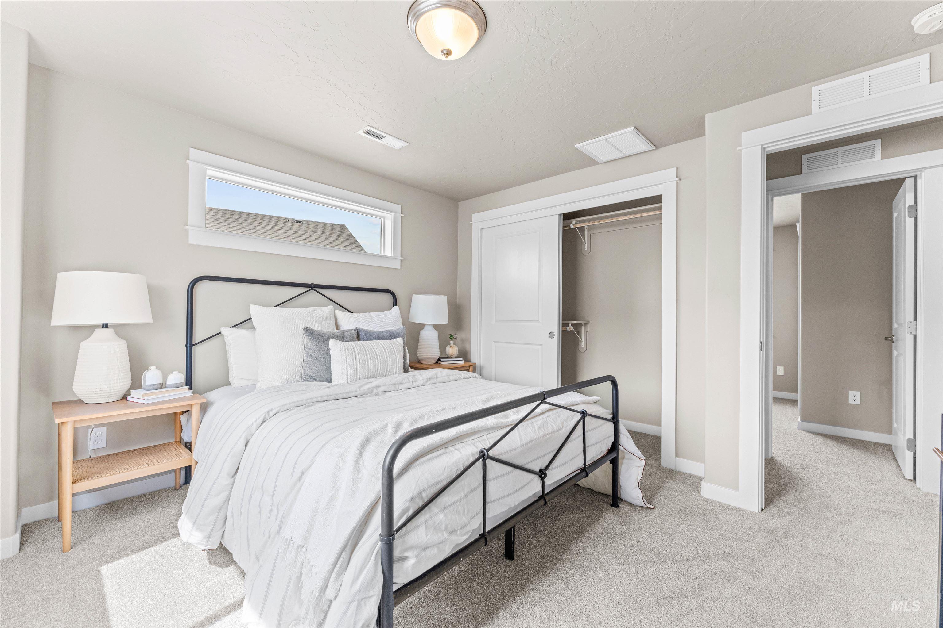 Bedroom with light carpet and a closet