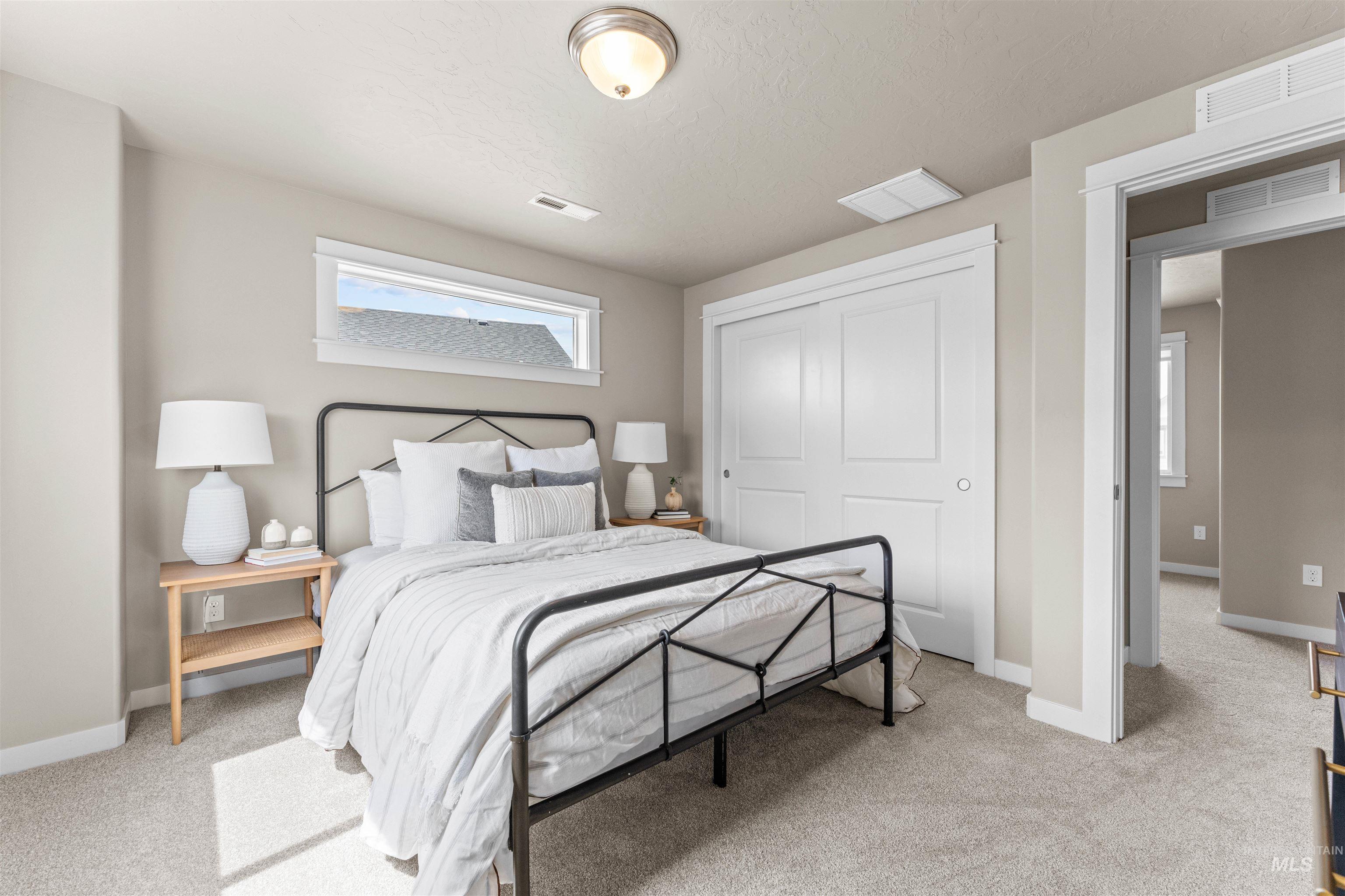 Bedroom featuring light carpet and a closet