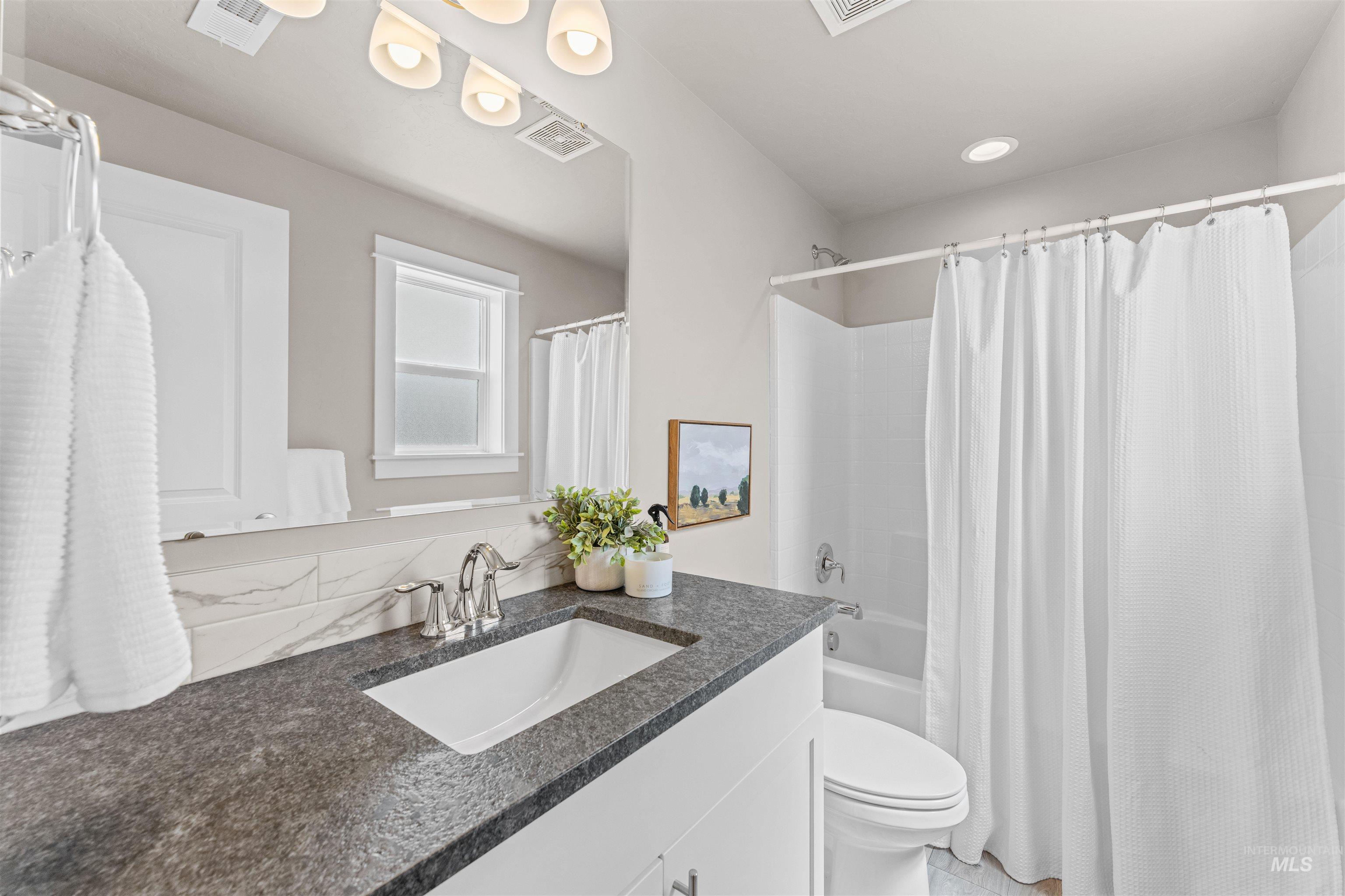 Full bath featuring vanity and shower / bathtub combination with curtain