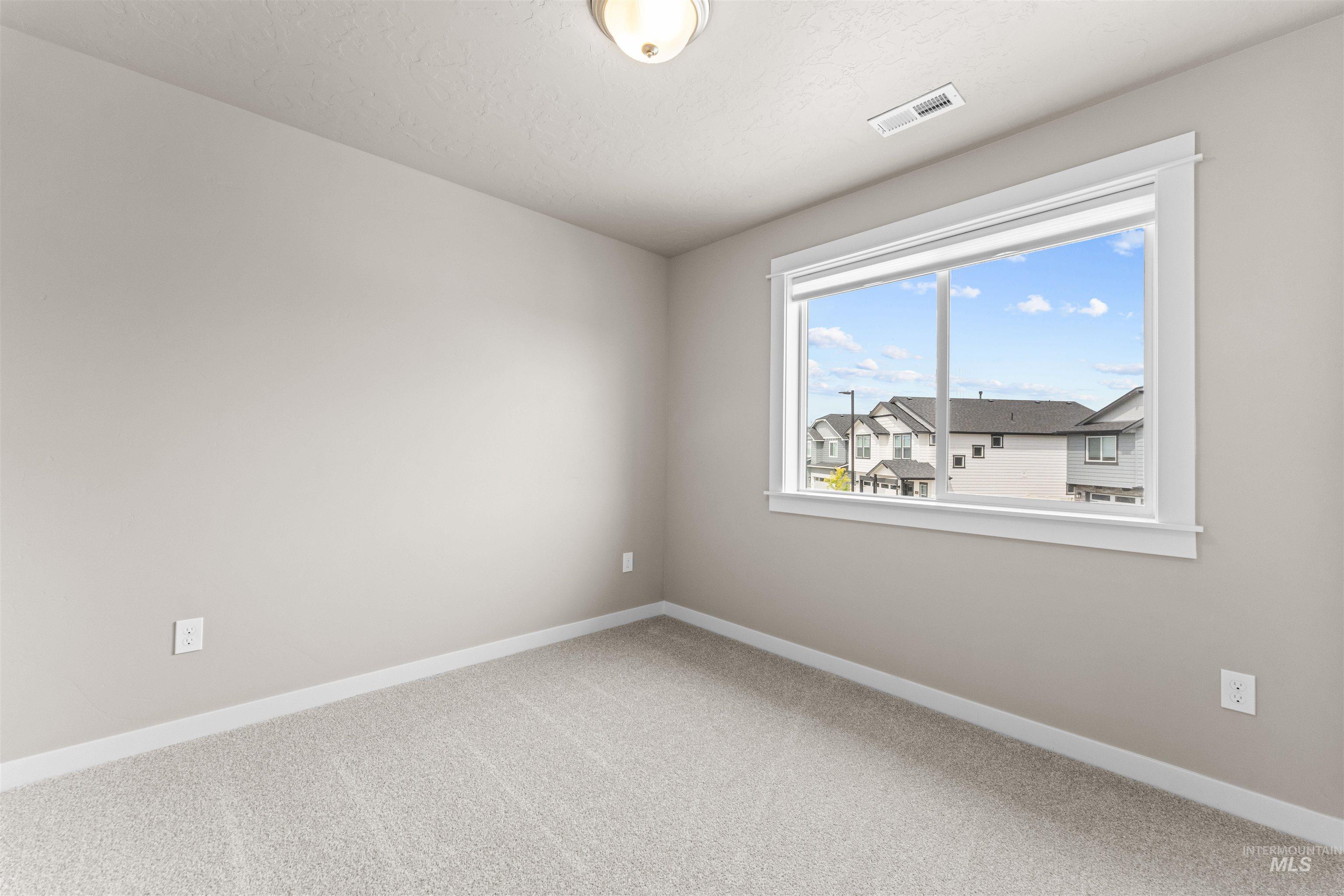 Carpeted spare room with baseboards