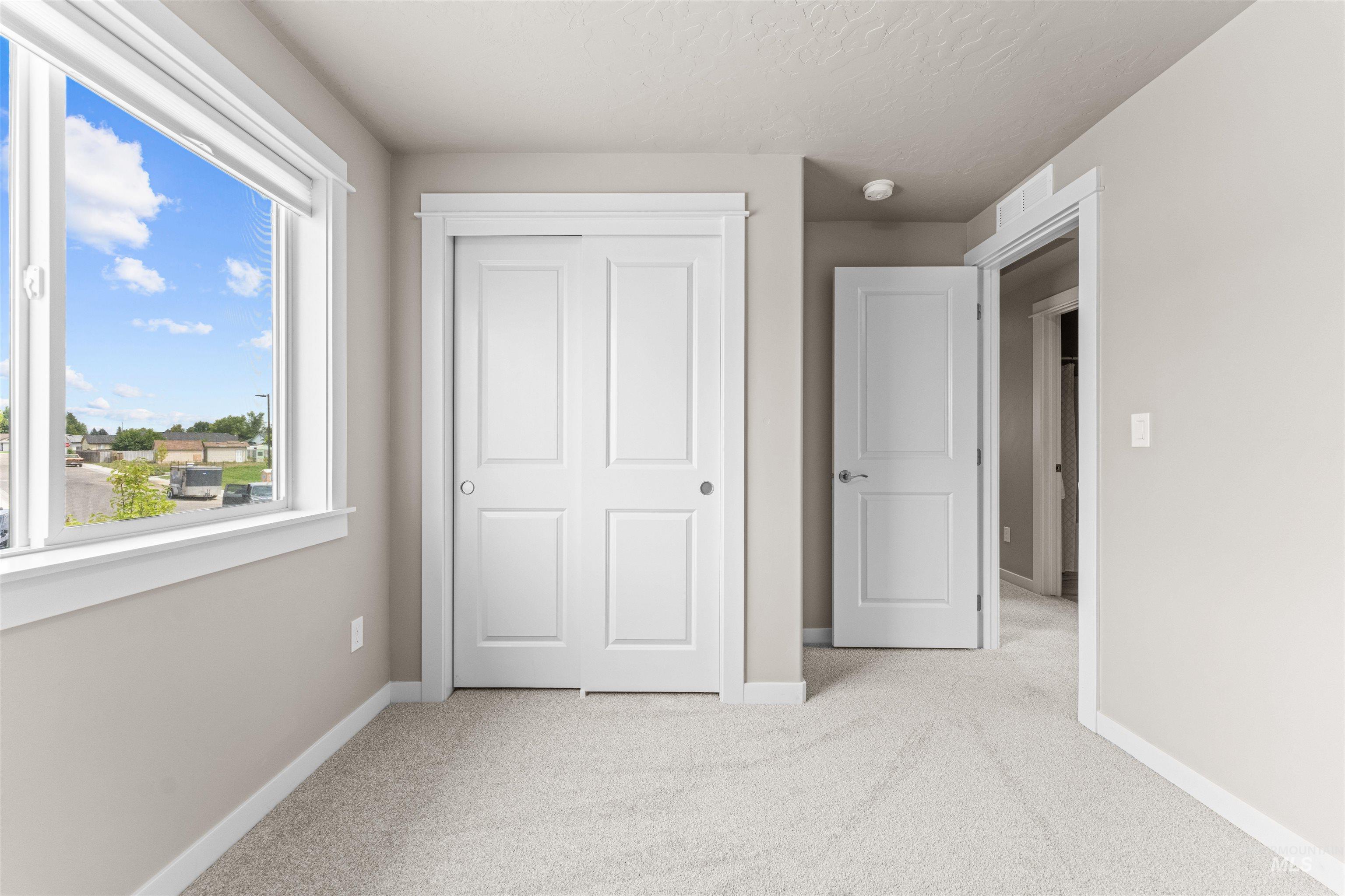 Unfurnished bedroom with light carpet, a closet, and a textured ceiling