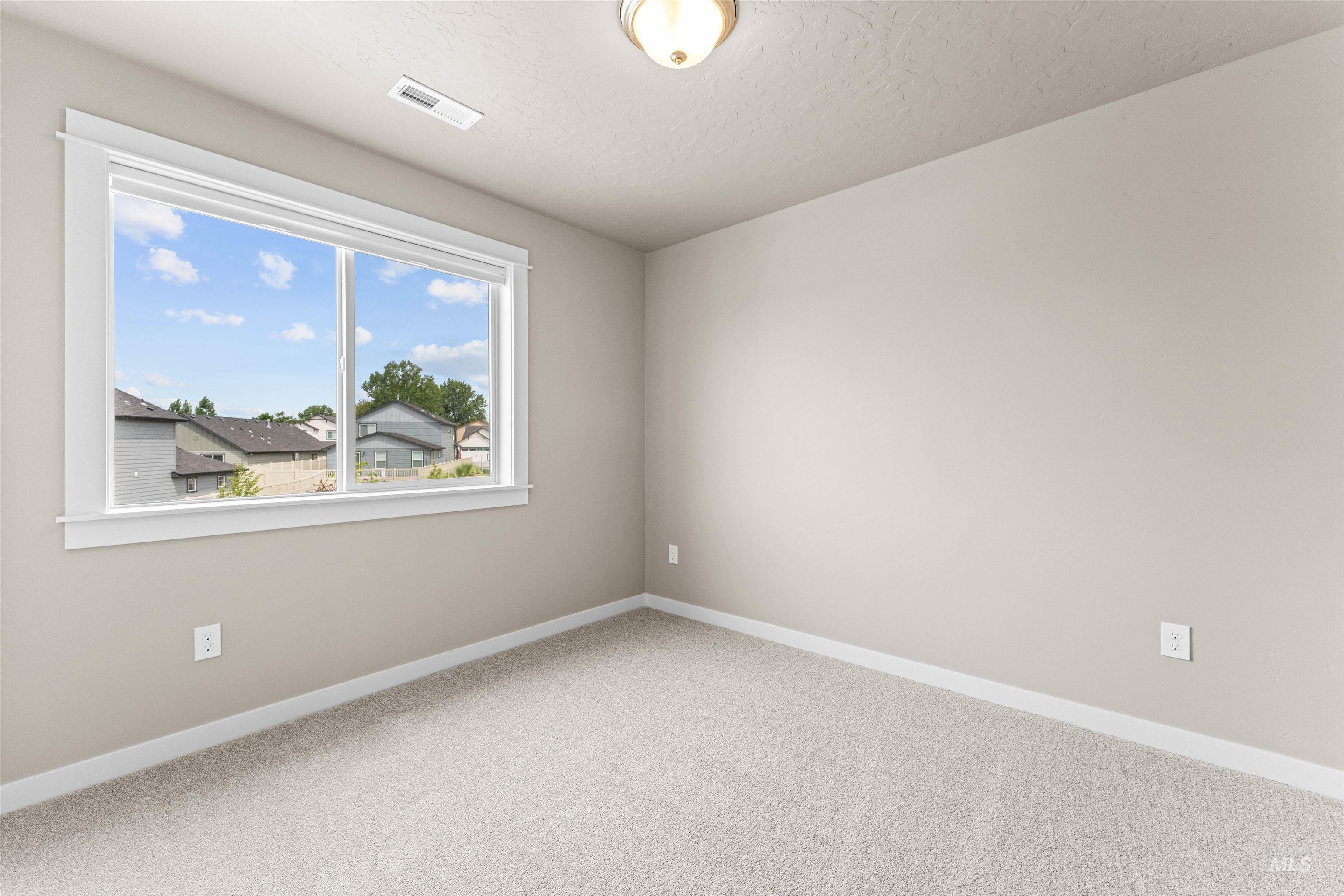 Carpeted spare room featuring baseboards