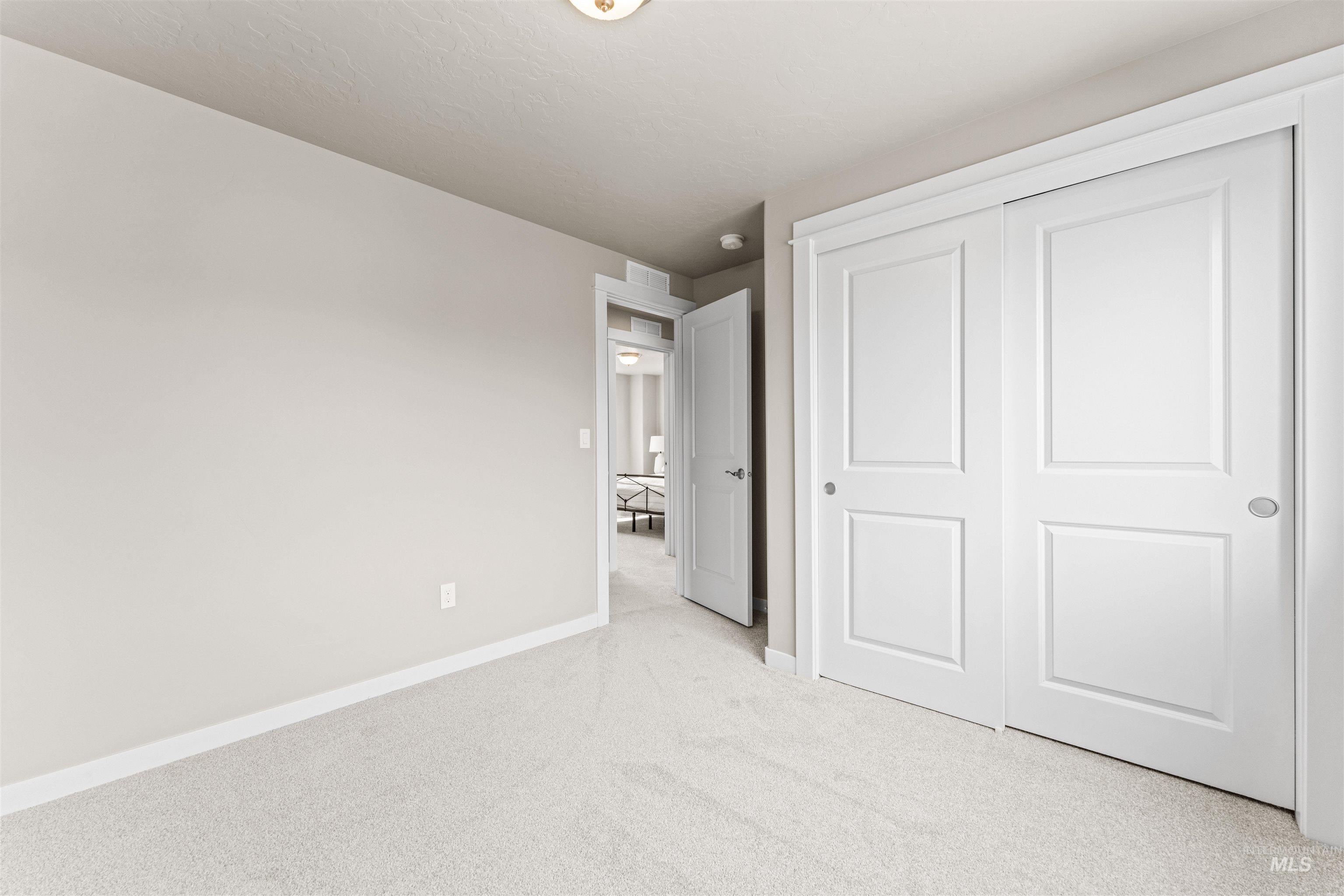 Unfurnished bedroom featuring carpet flooring and a closet