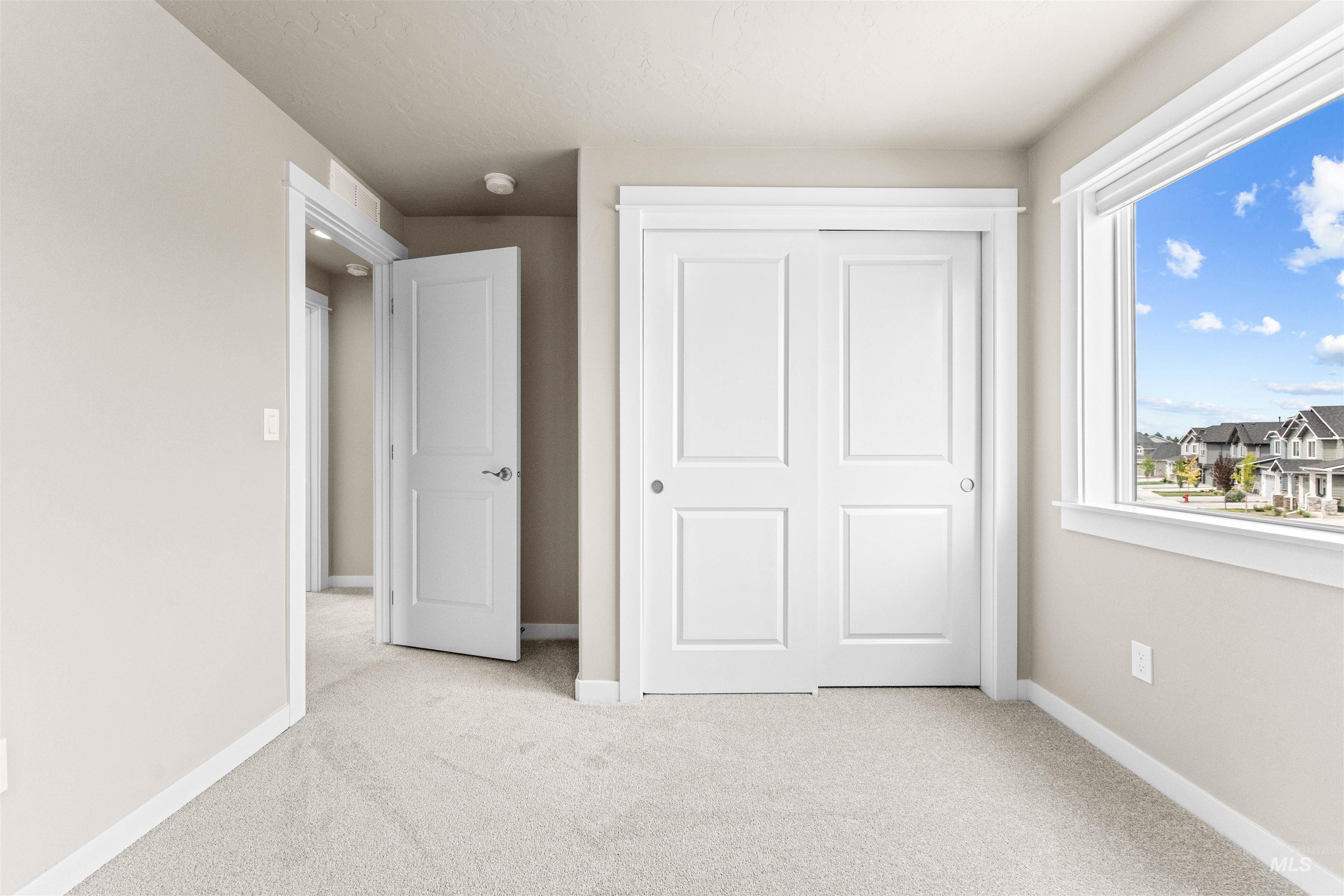 Unfurnished bedroom with light carpet and a closet