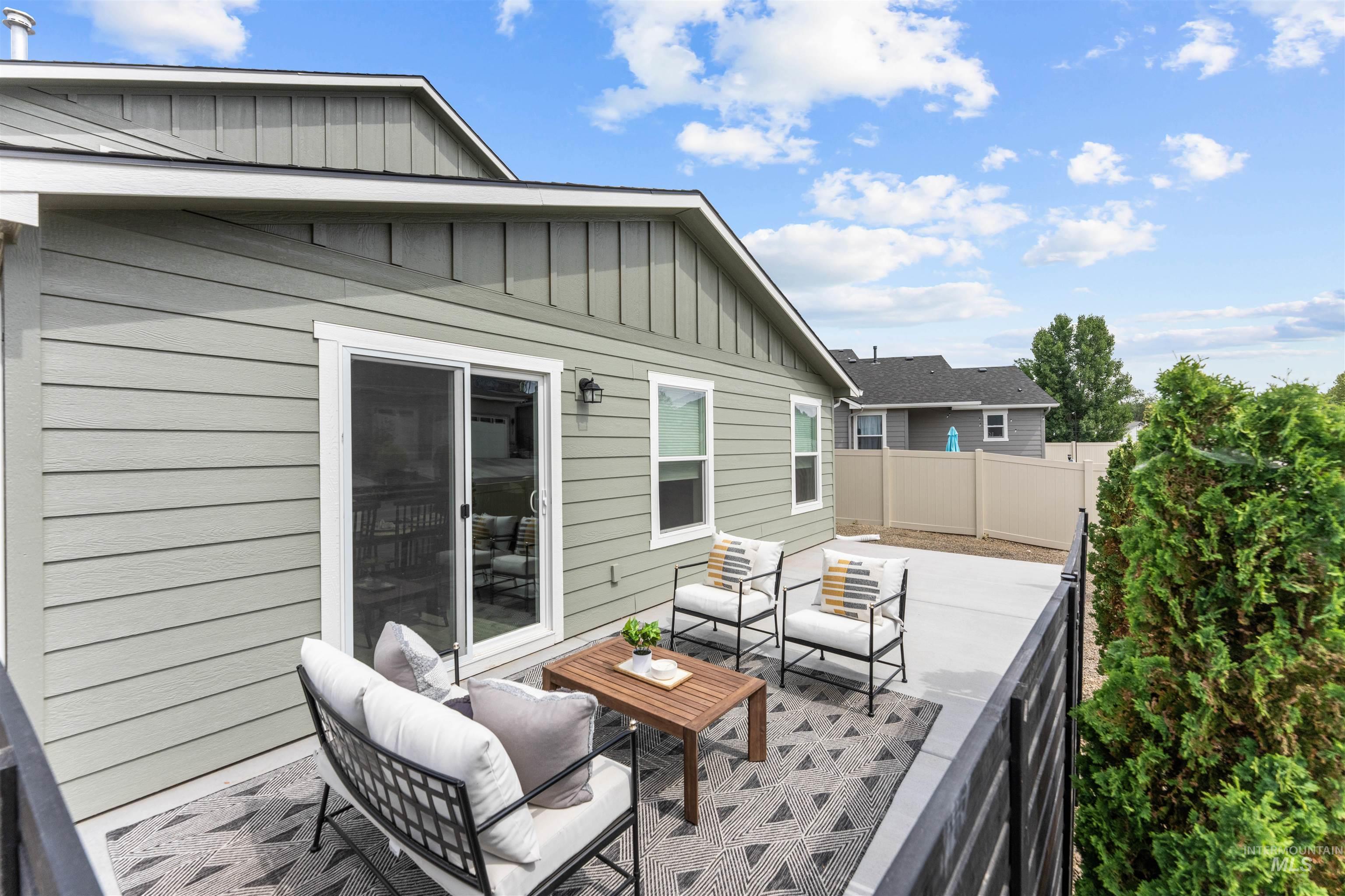 Rear view of house featuring an outdoor living space, board and batten siding, and a patio