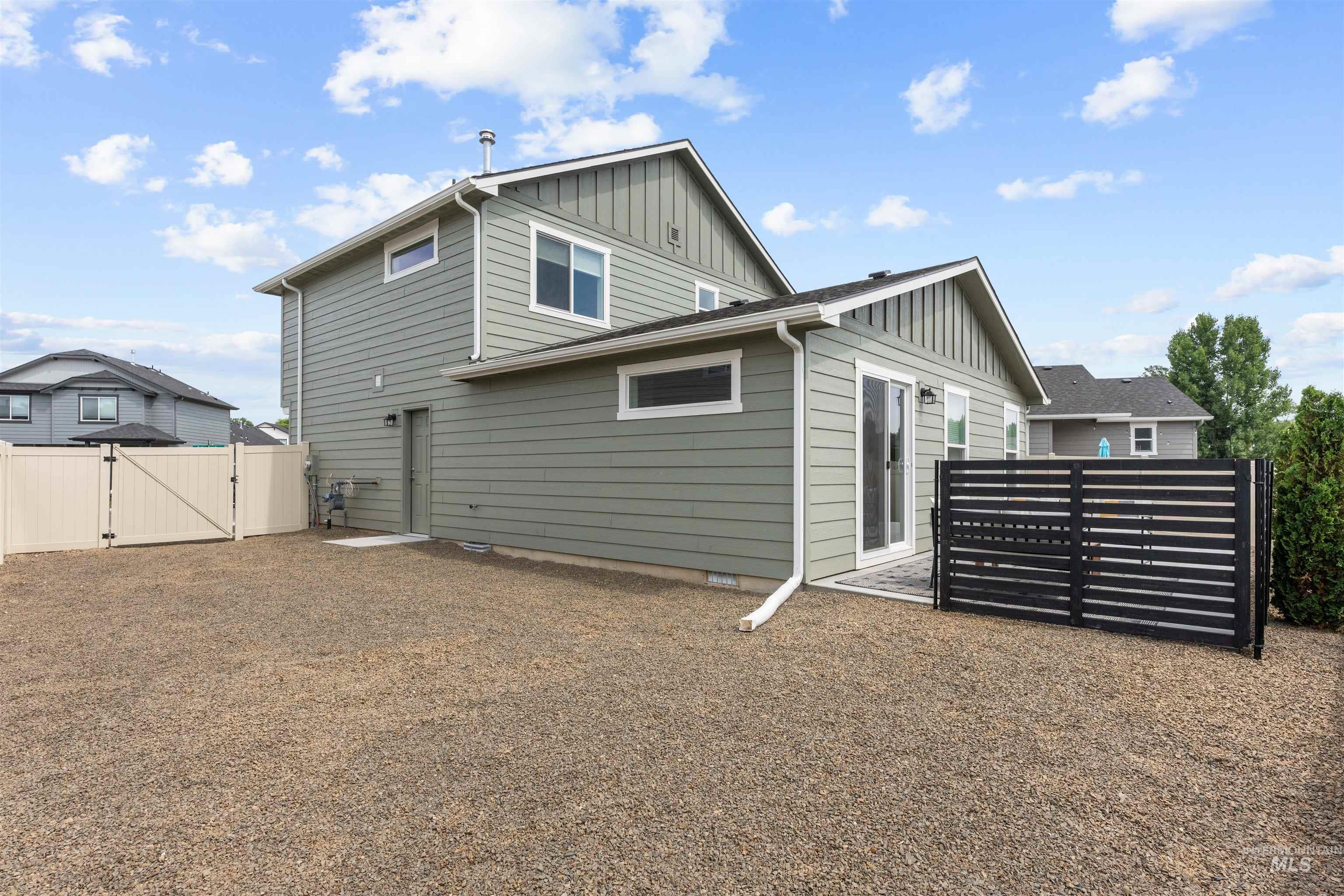 Rear view of property featuring board and batten siding and a gate