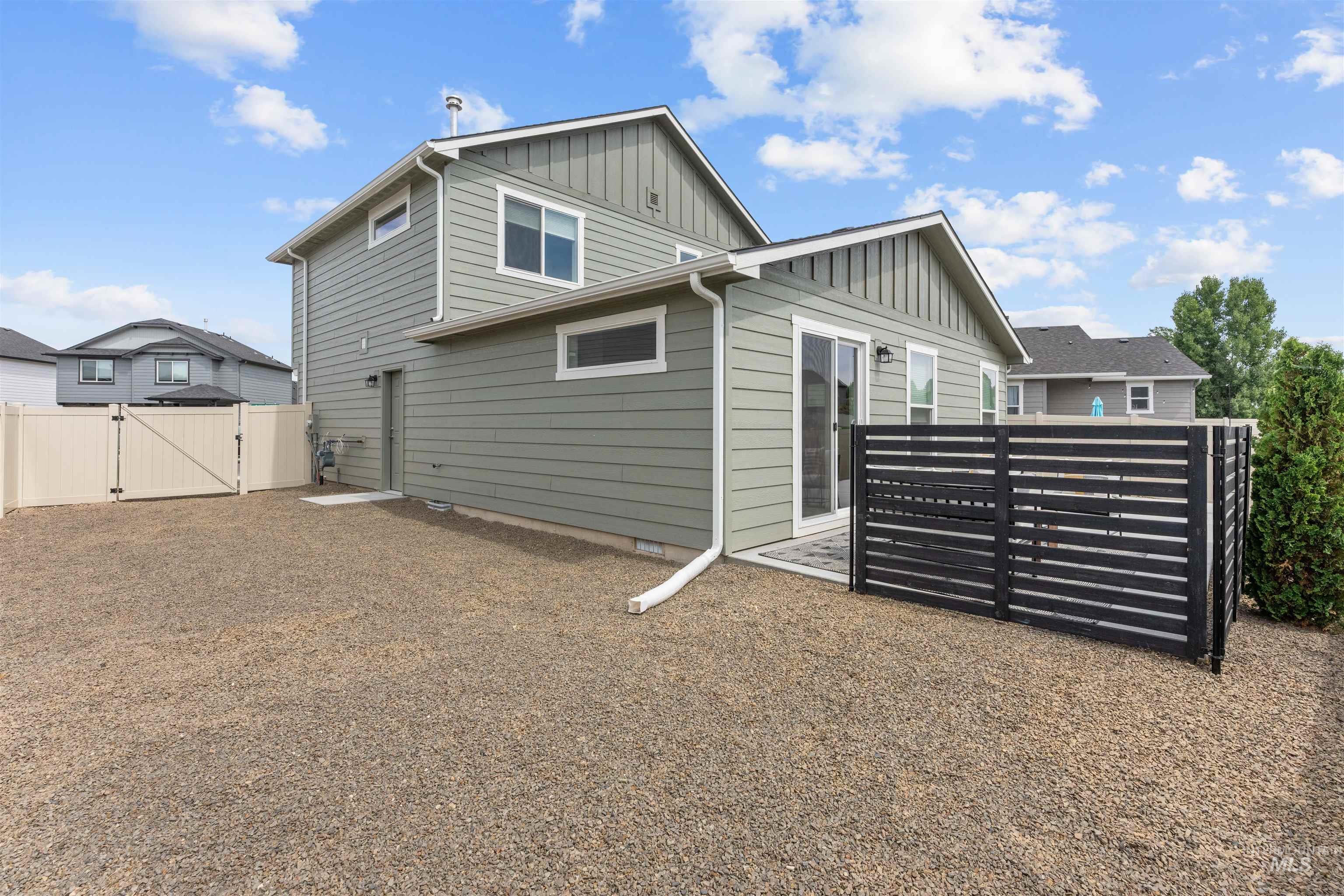 Rear view of house featuring board and batten siding and a gate